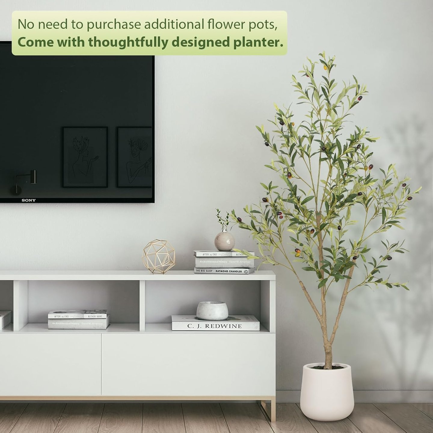 Artificial olive tree in a white planter standing next to a modern TV stand.