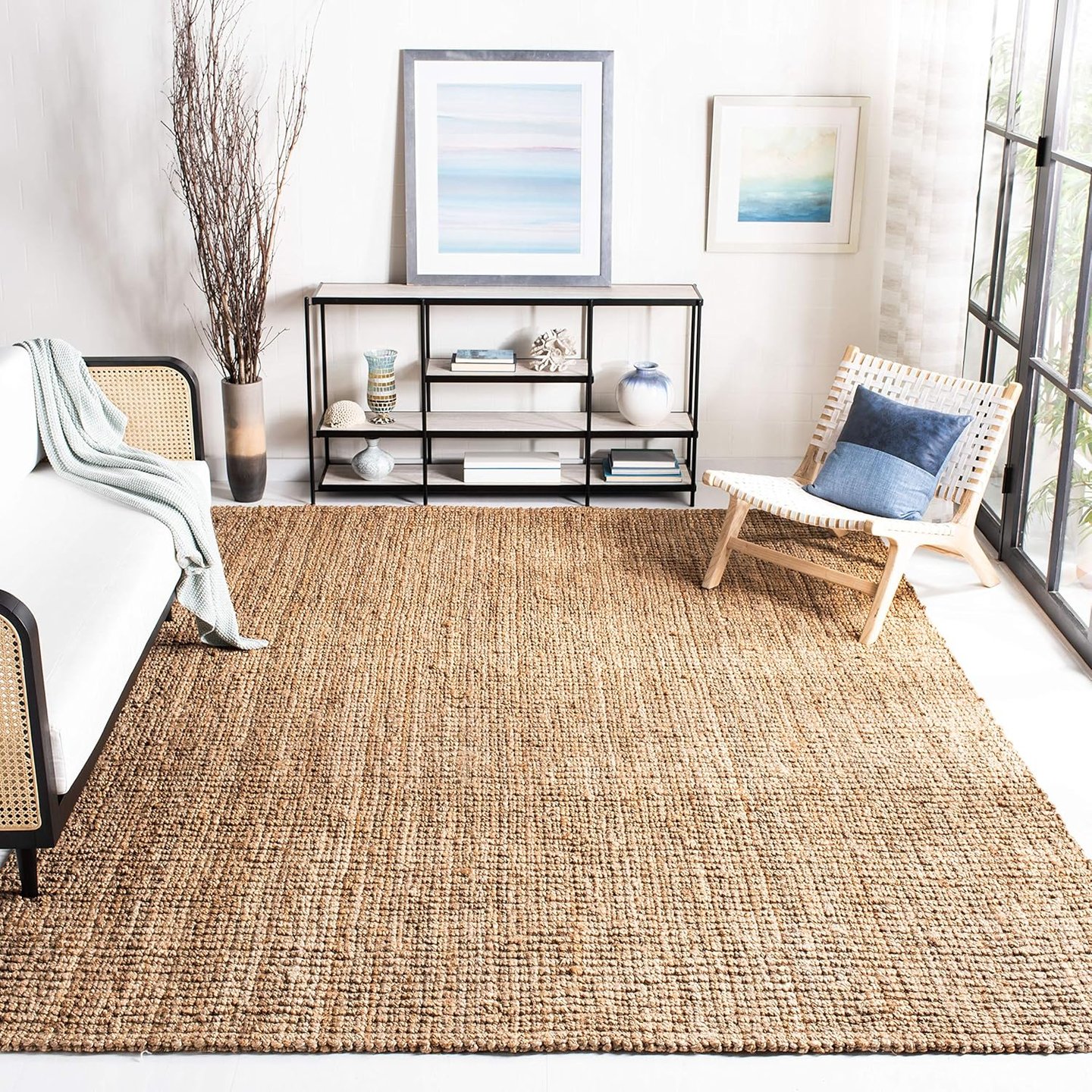 Natural jute area rug in a modern living room with a woven accent chair and console table.