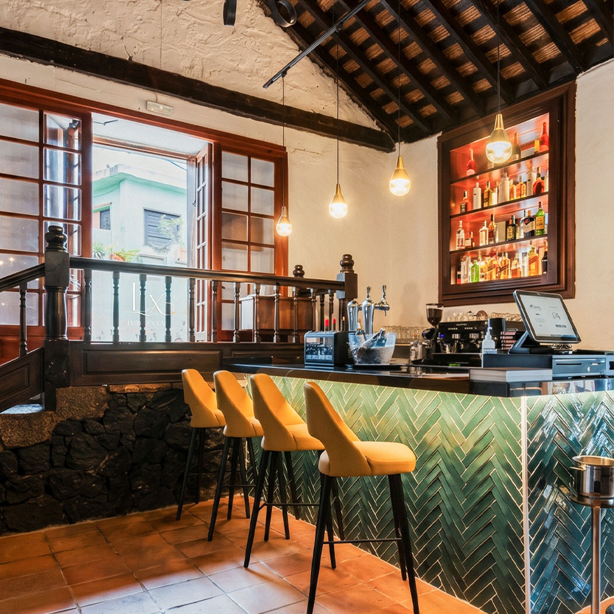Interior de Esterlicia con barra de cerámicos verdes y arquitectura con vigas