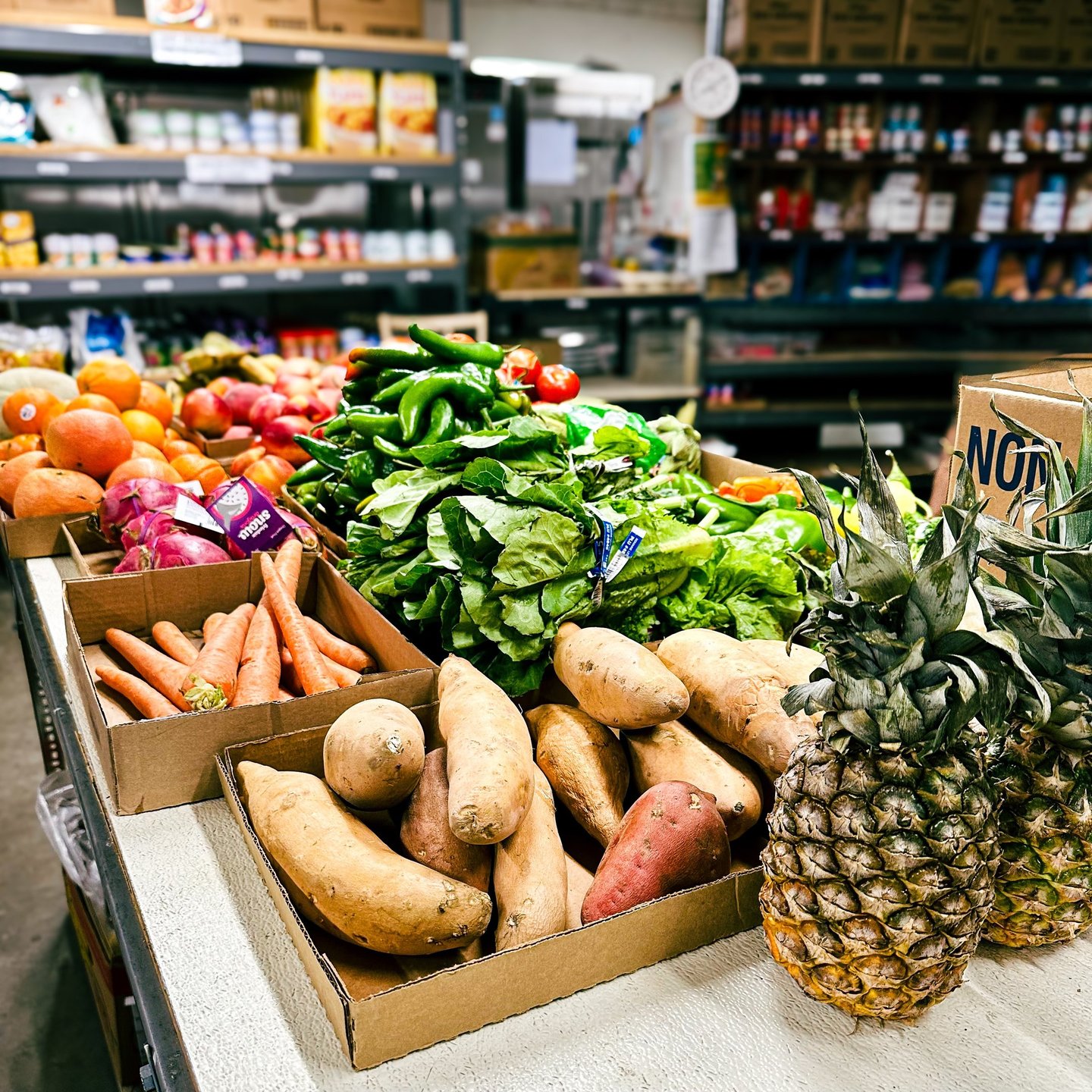 Pantry interior with table of fresh produce and shelves with canned and boxed food