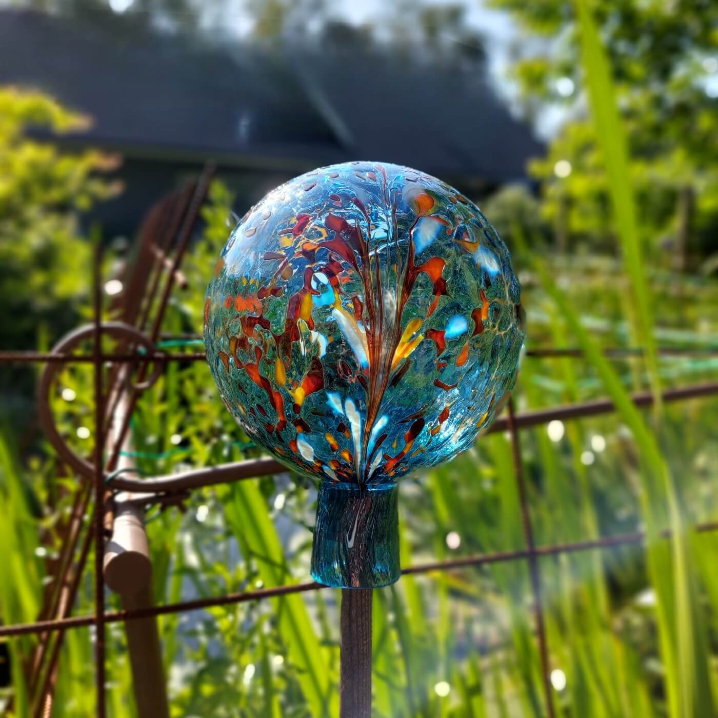 Ankes glaskulor framför en dam i trädgård aqua
