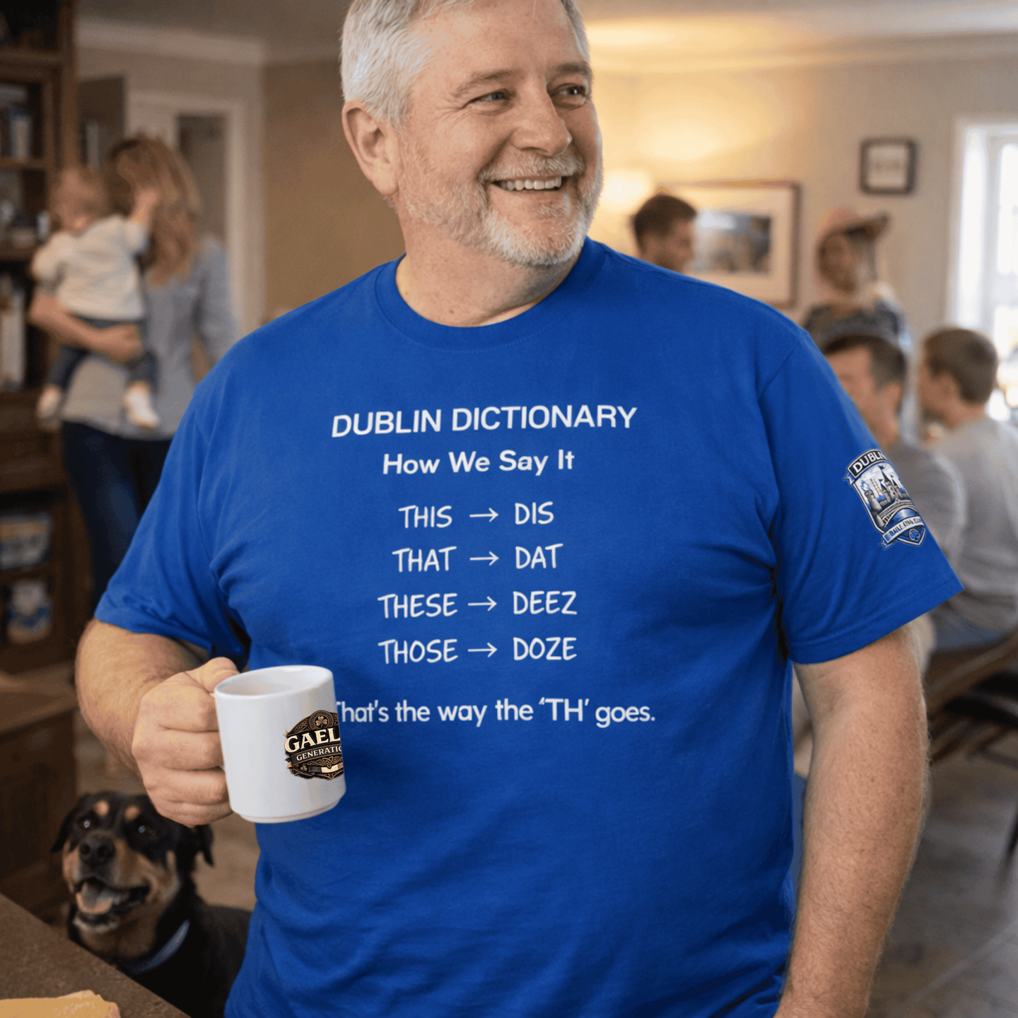 A smiling man wearing a blue Dublin Dictionary t-shirt while holding a white coffee mug.