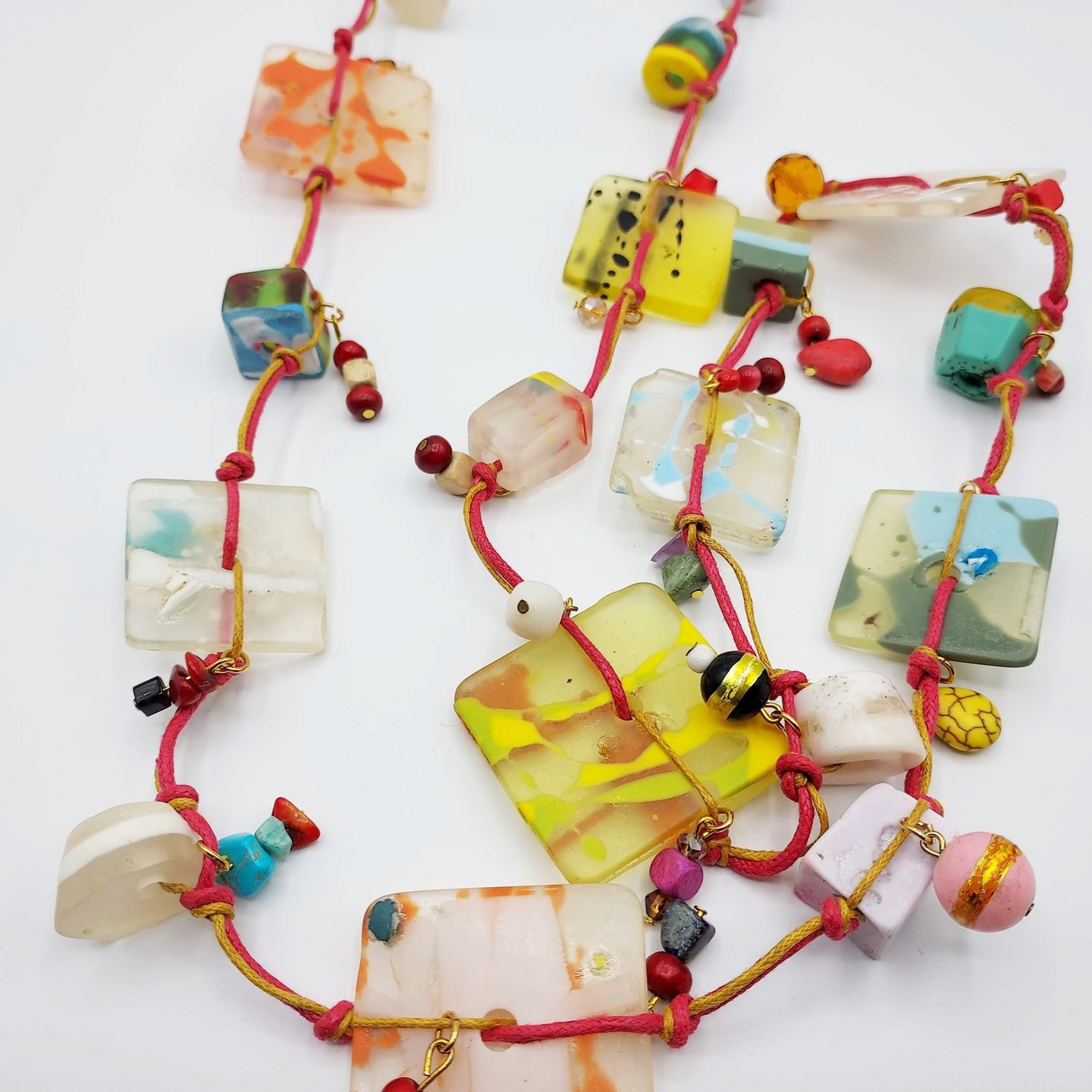 C'est un long collier très coloré réalisé en résine.