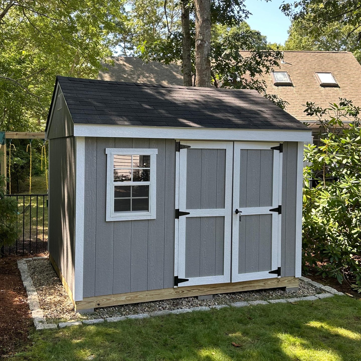 Custom 8x10 wooden shed with double doors and window, built in Halifax, Massachusetts for functional backyard storage.
