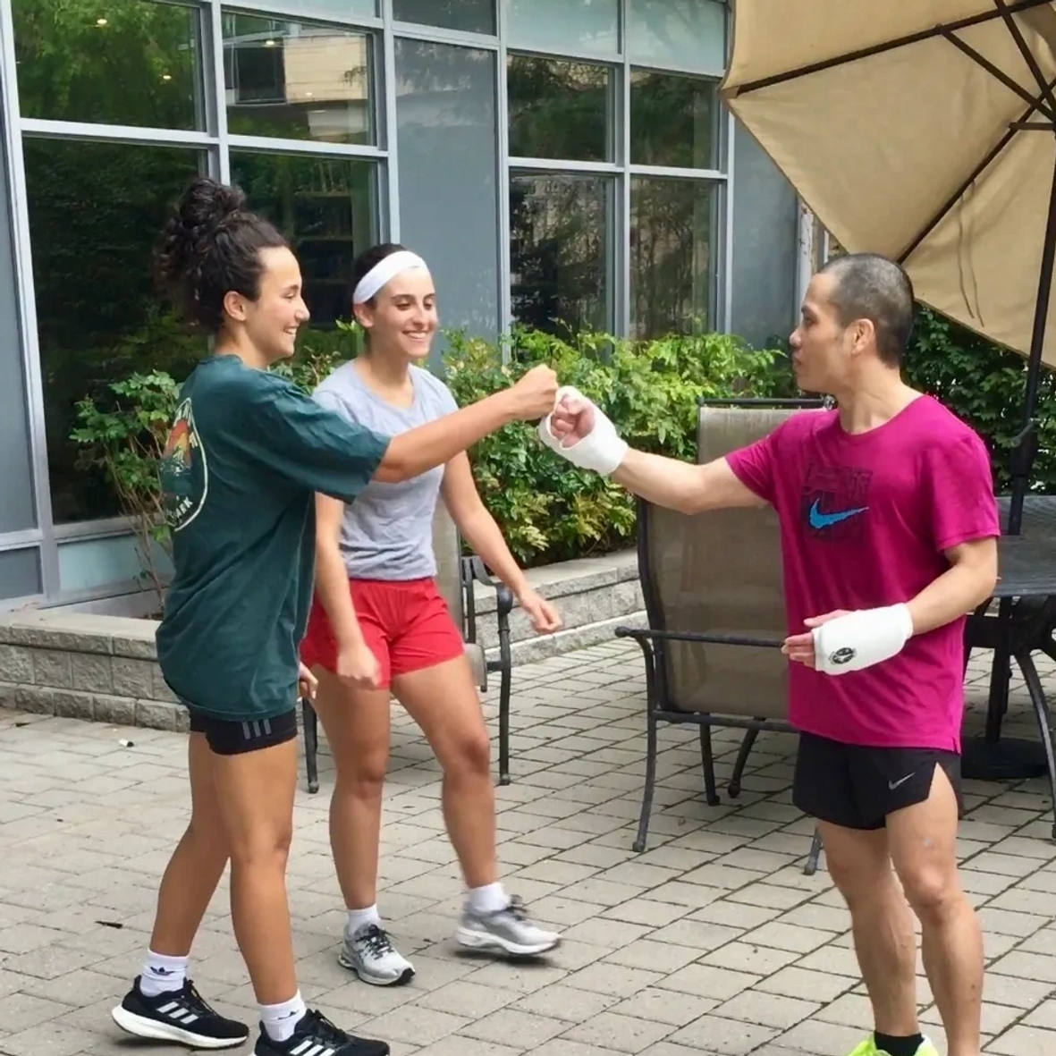 A woman is giving a fist bump to MARK RECAIDO after training Jeet Kune Do North York!