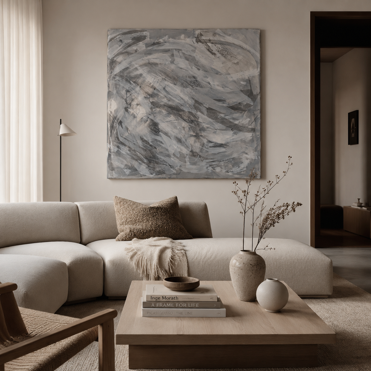 Modern minimalist living room featuring a curved beige sectional sofa and large abstract wall art.