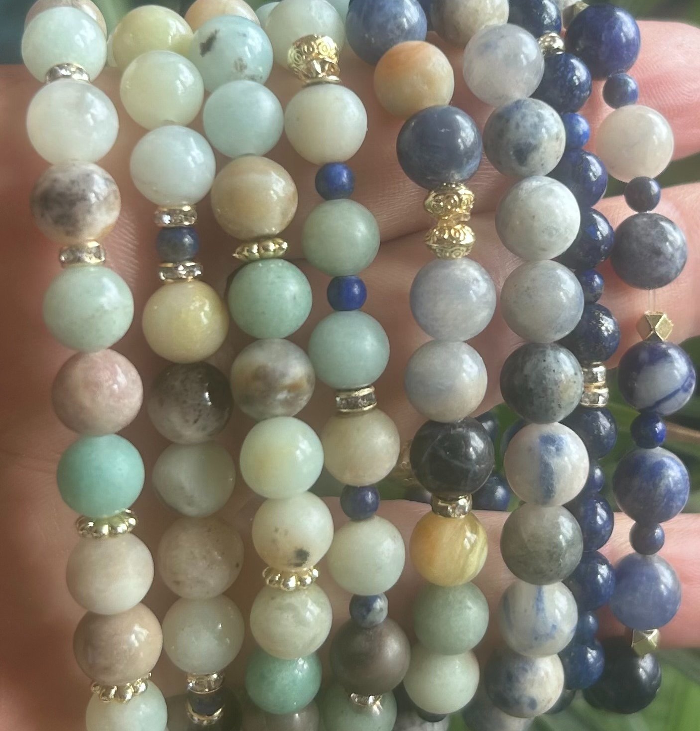 a person holding a bunch of beads and a bracelet