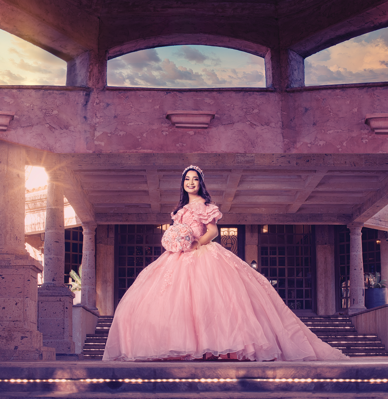 a woman in a pink dress standing on stairs