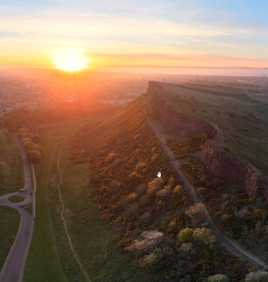Aerial drone view of Salisbury Crags in Holyrood Park Edinburgh at golden hour sunrise