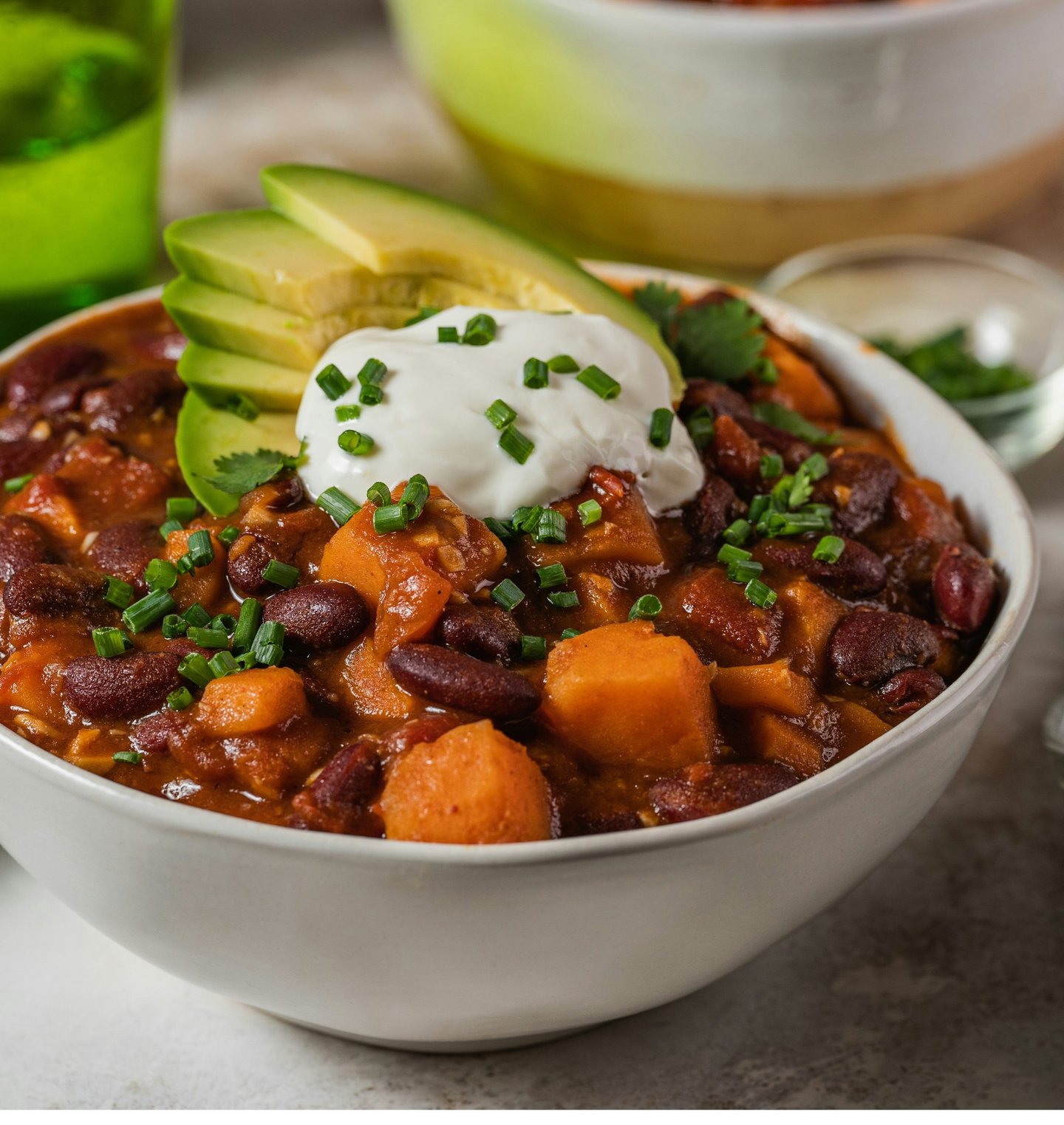 Bowl with vegan chili sin carne with beans, vegetables, vegan topping yogurt and avocado