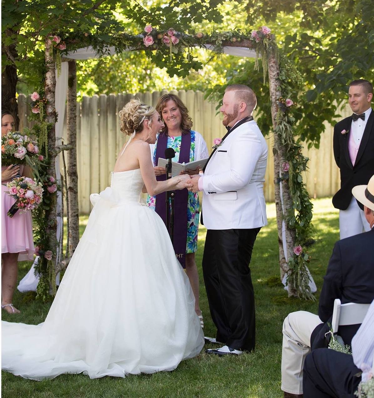 Wedding officiant with couple during outdoor wedding ceremony