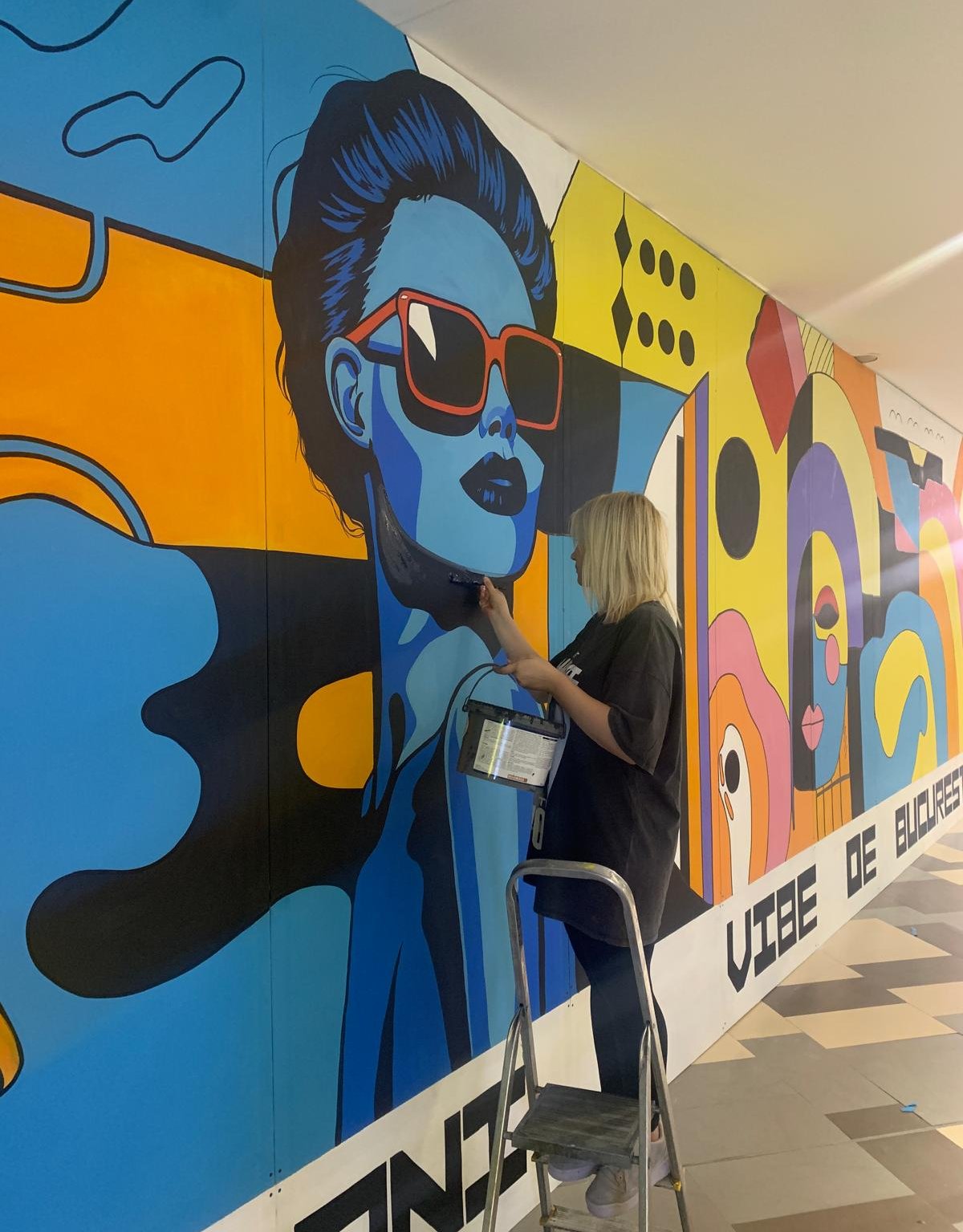 Artist lucrând la pictură murală mall.