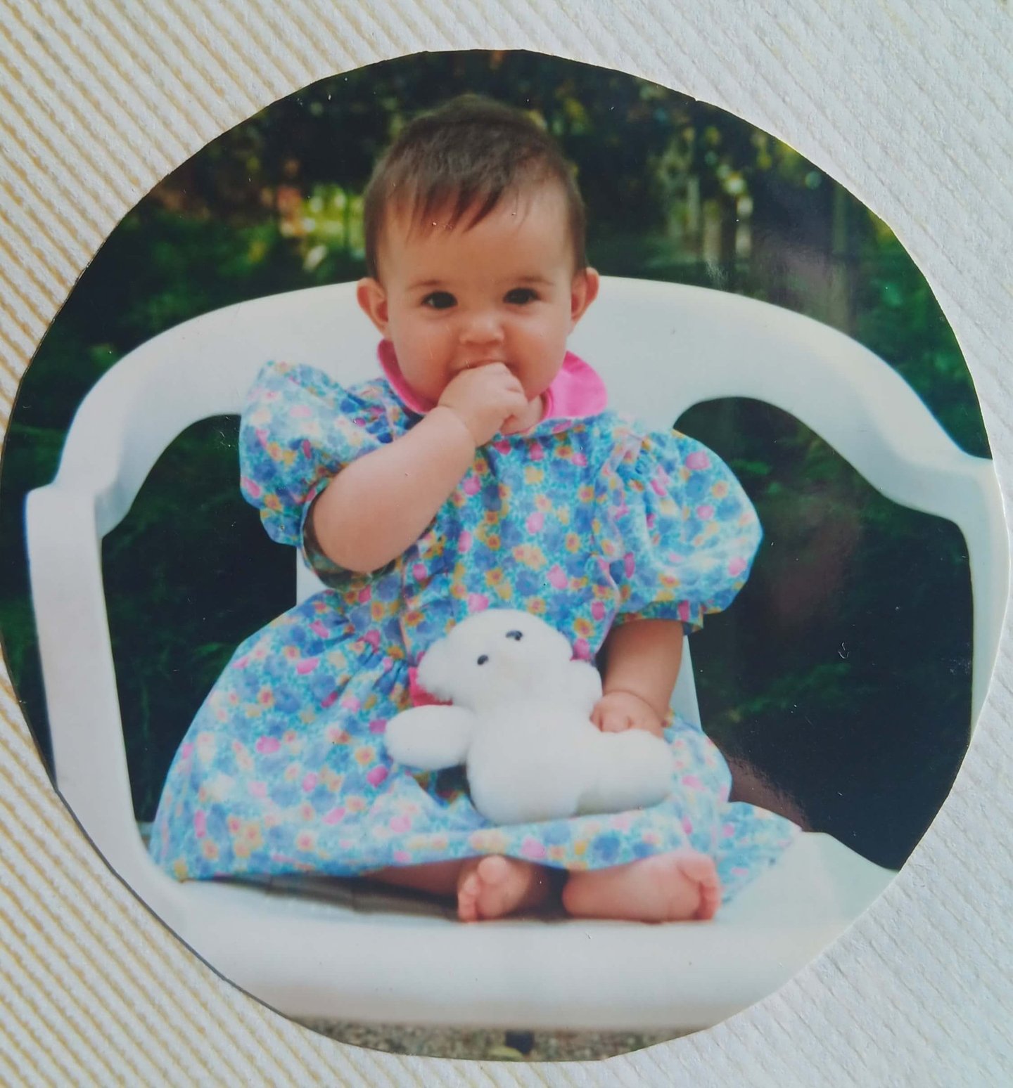 Natacha bébé tenant sa peluche blanche contre elle