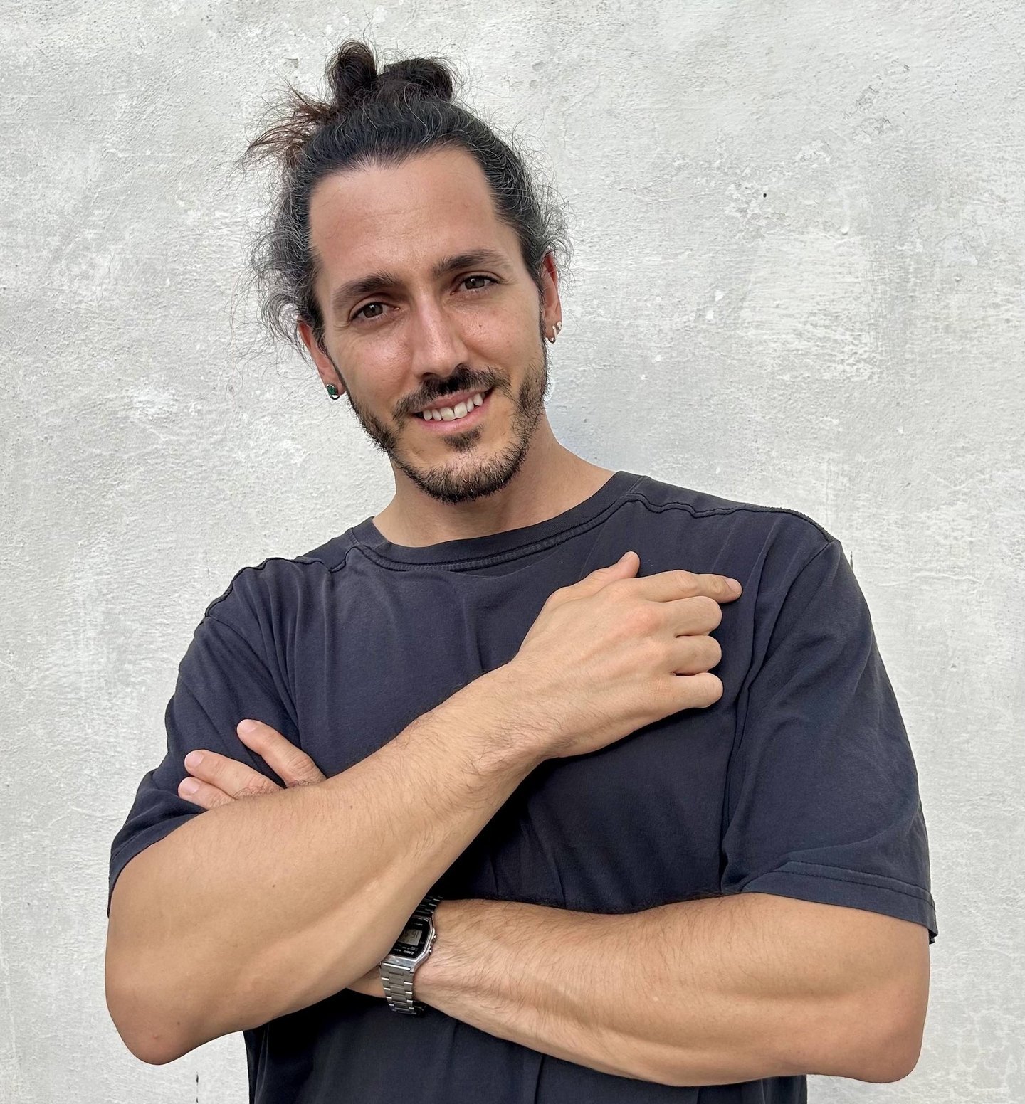 Borja Llegó posando de brazos cruzados frente a una pared gris, creador de contenido de viajes y gas