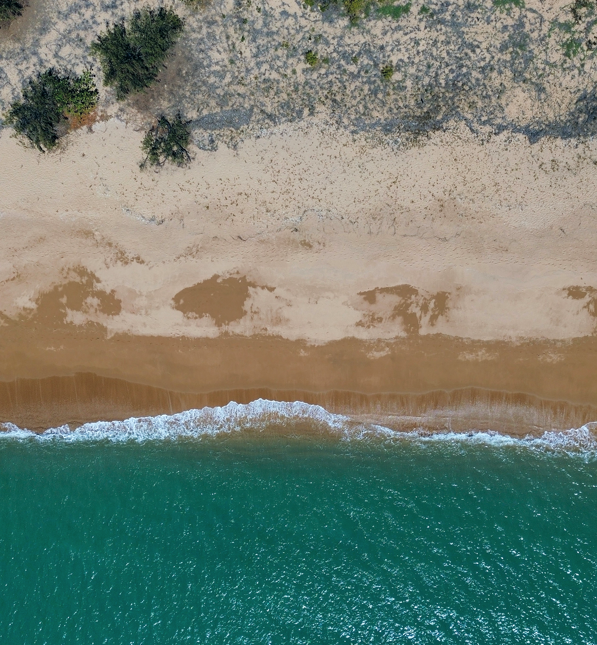 Playa de arena y agua cristalina vista desde arriba
