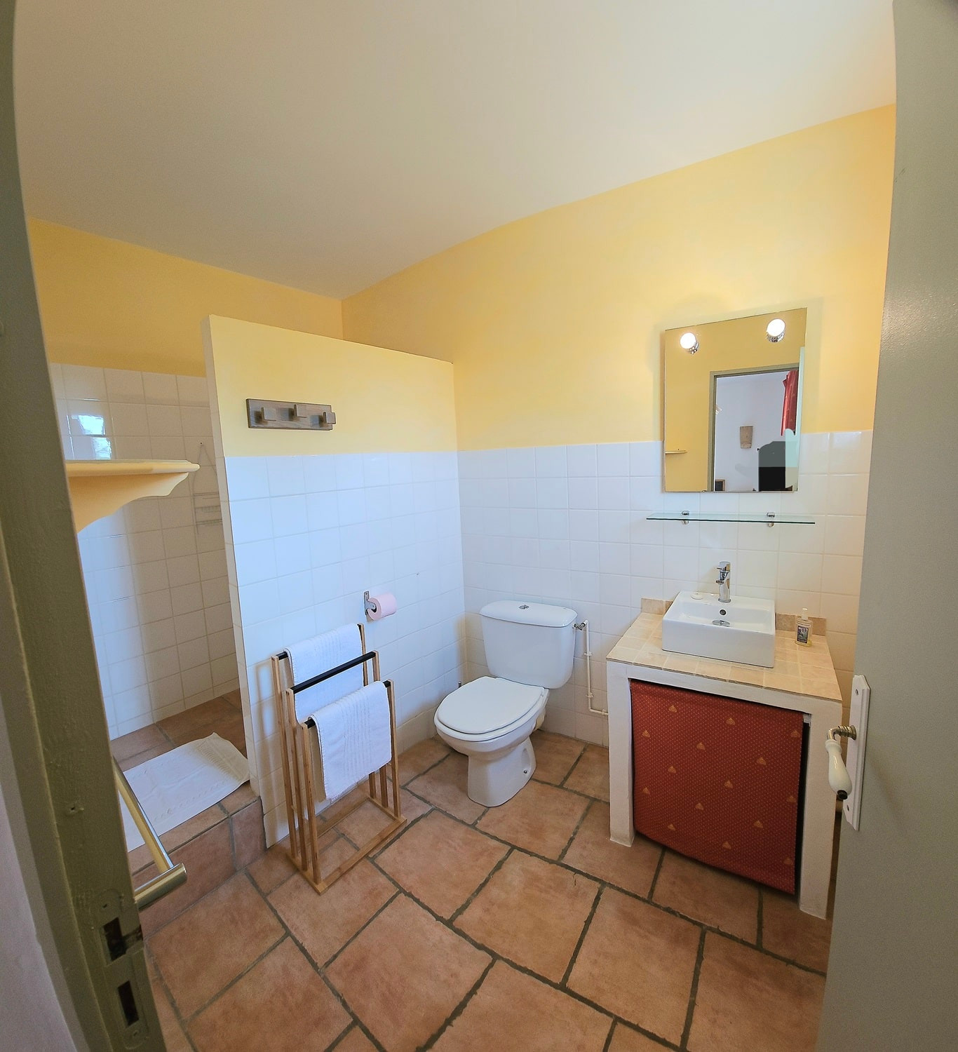Salle de bain chambre Olivier avec douche à l'italienne, wc, et vasque couleur ton mur jaune pâle.