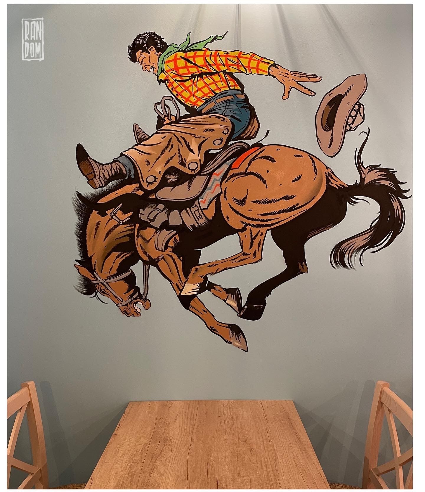 mural de un baquero a caballo en una pared de un restaurante