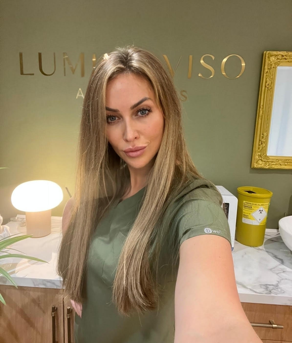 a woman in a green dress standing in LuminaViso Wokingham