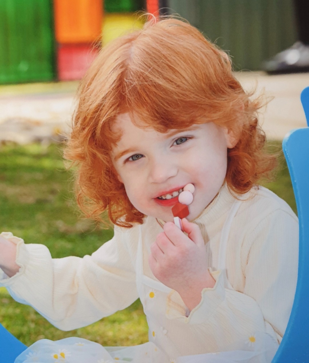 a young girl with red hair and a white shirt