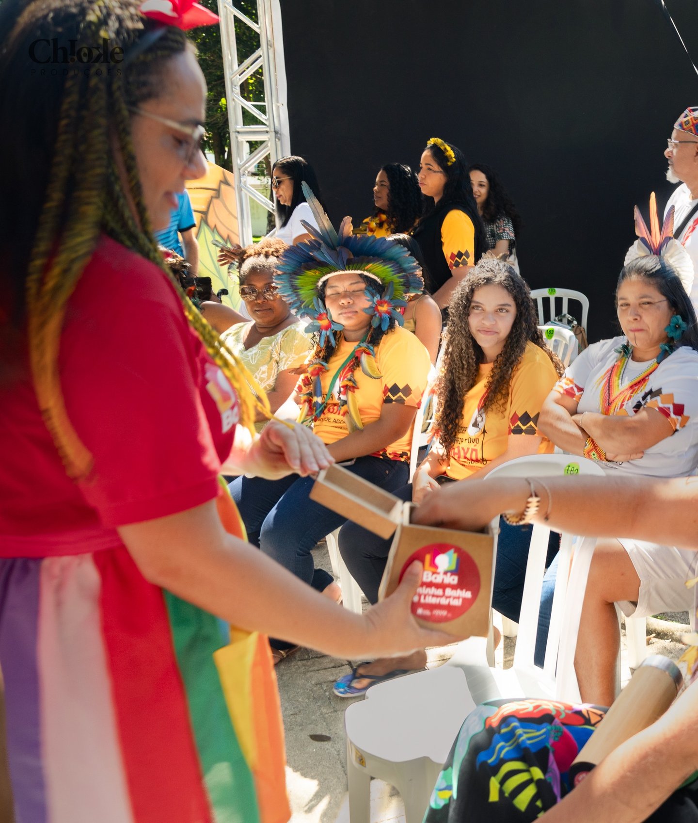 Mulheres sentadas em uma feira literária indígena
