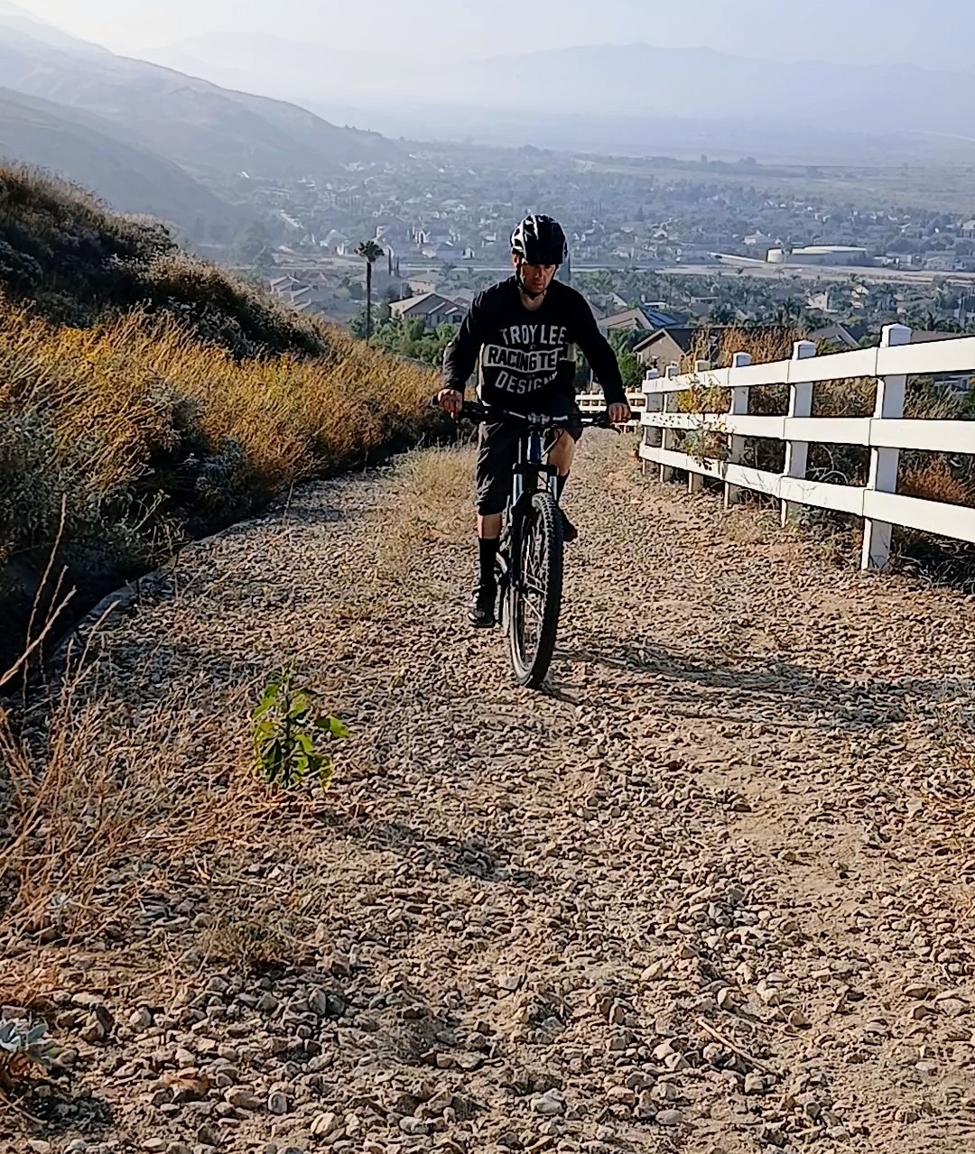 Mountain biker climbing a loose gravel trail, staying seated for traction and control