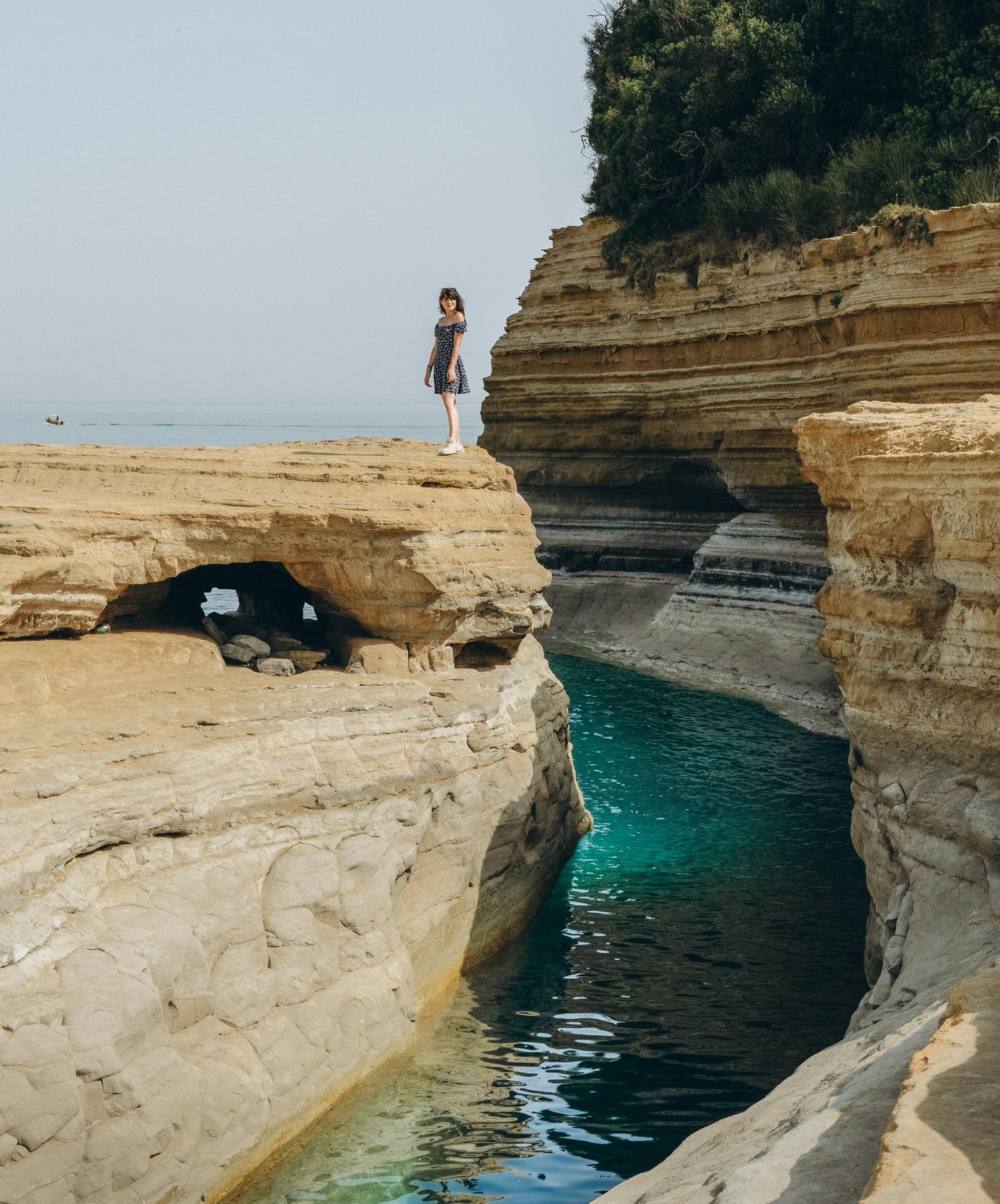 a woman standing on a cliff overlooking the ocean