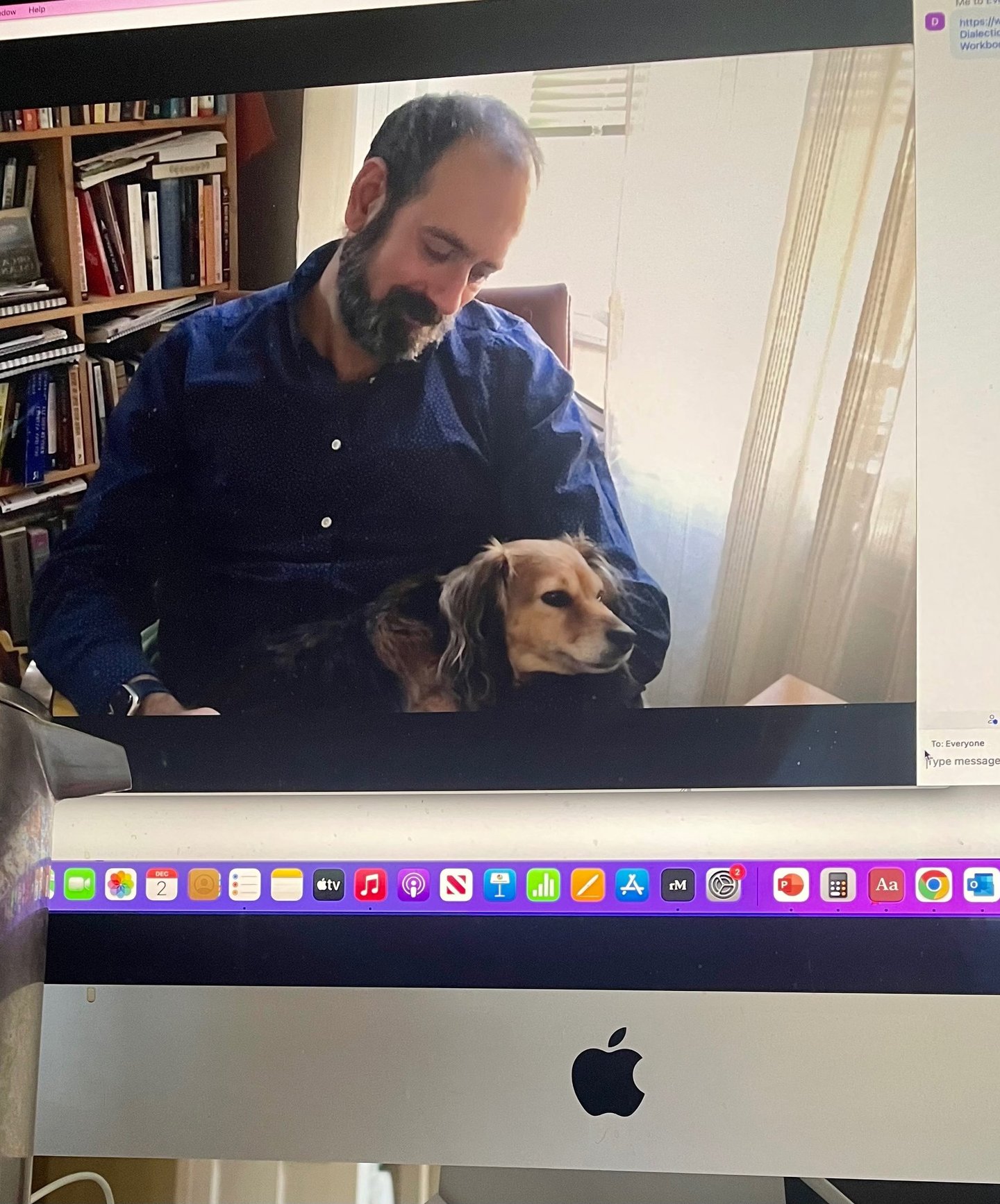 Therapist psychologist sitting on chair with small dog on his lap