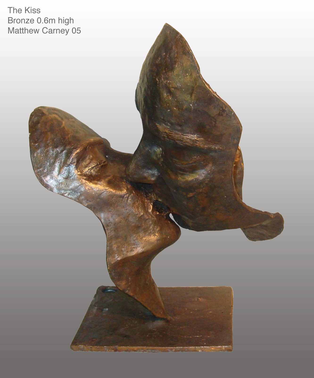 a bronze sculpture of two faces kissing