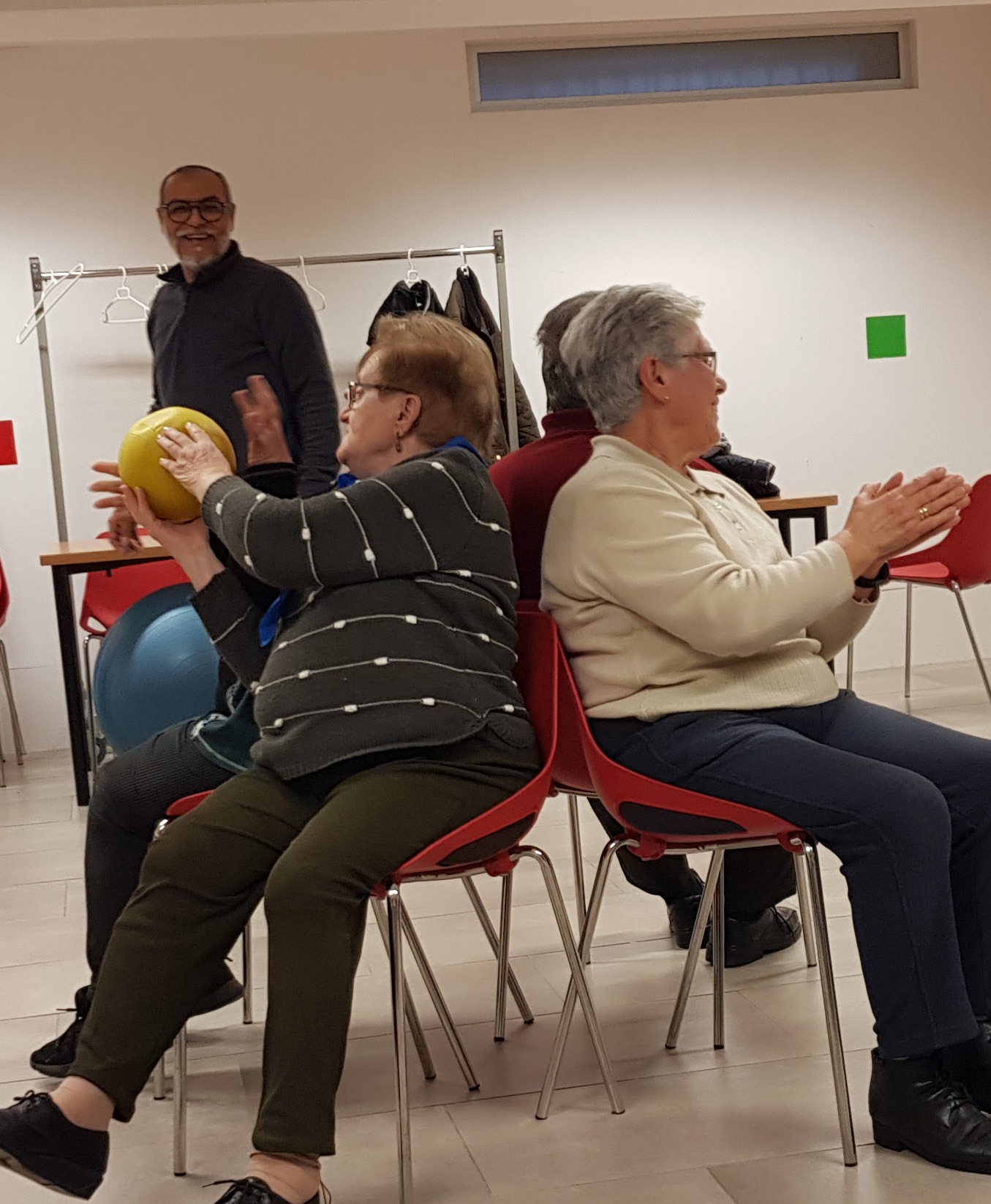 un grupo de personas mayores realizando unos ejercicios de movilidad asistido por un profesional