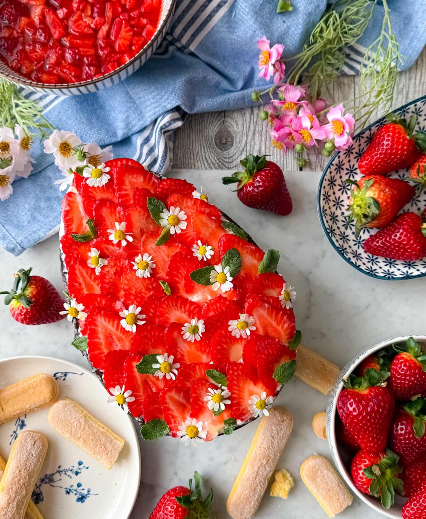 Tiramisù di Pasqua decorato con fragole e fiori edibili visto dall’alto