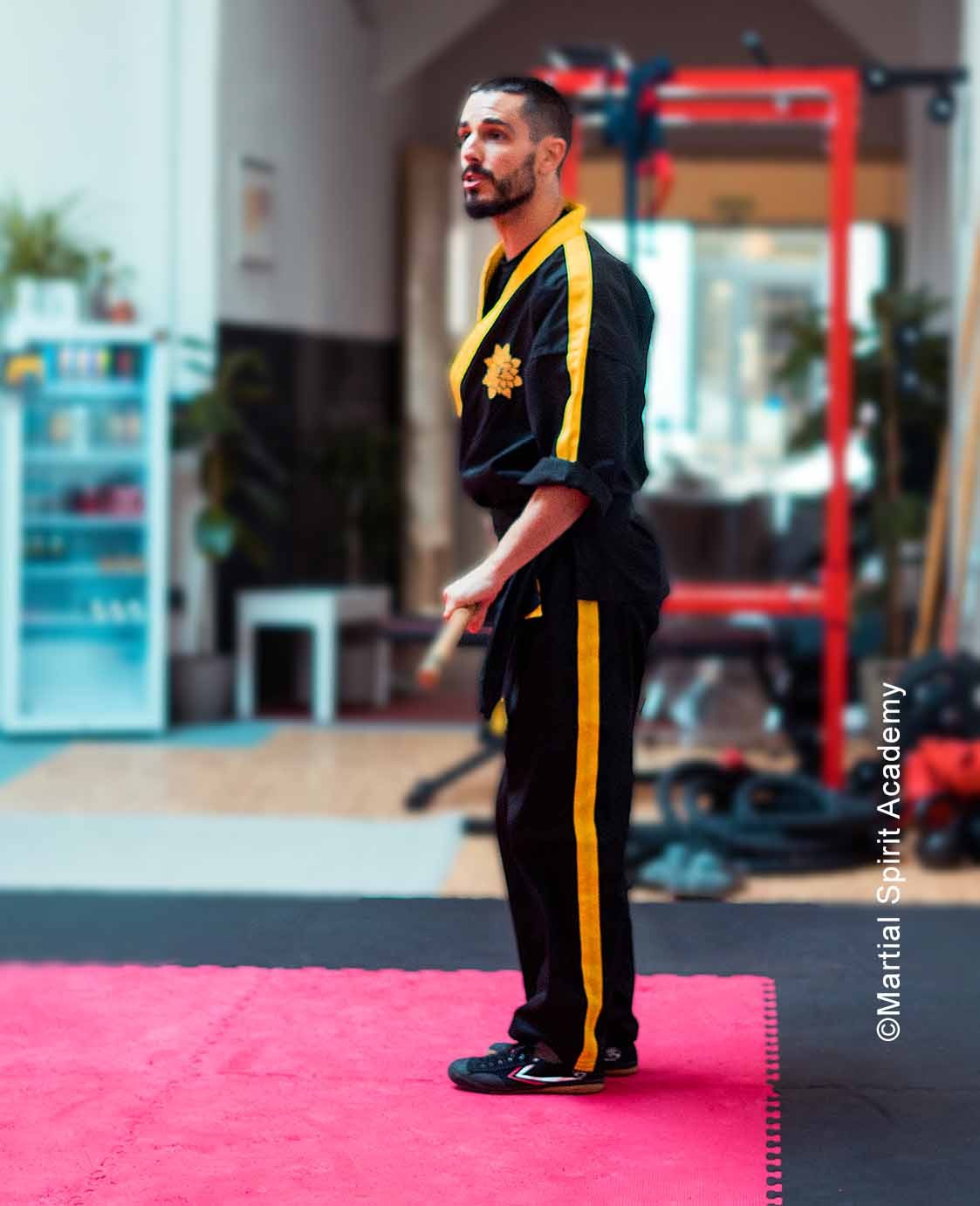 a man in a black and yellow uniform standing on a pink carpet