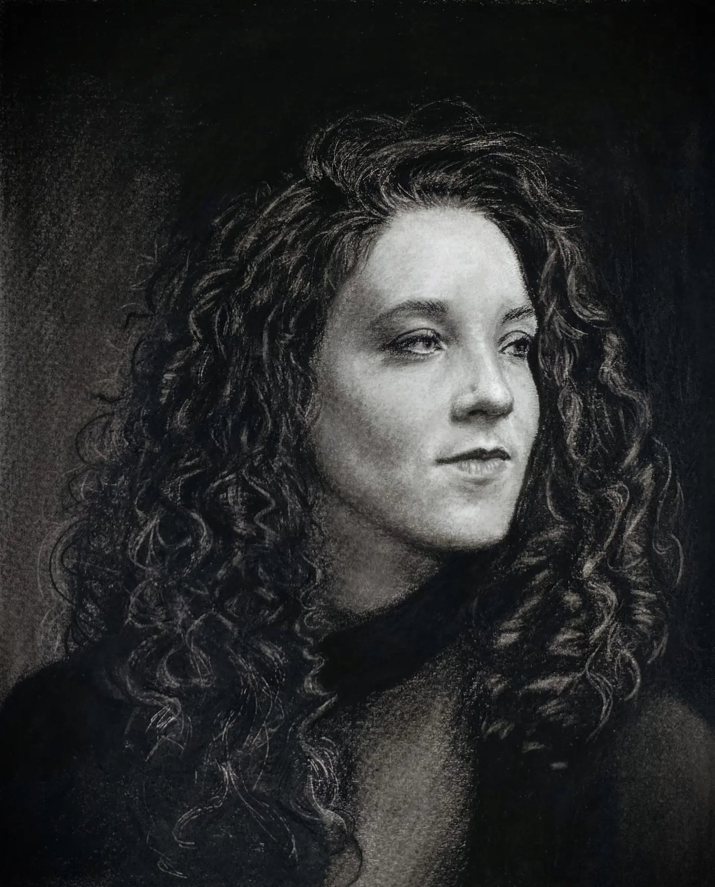 Detailed charcoal and graphite portrait of a woman with curly hair, showing intricate light and shad