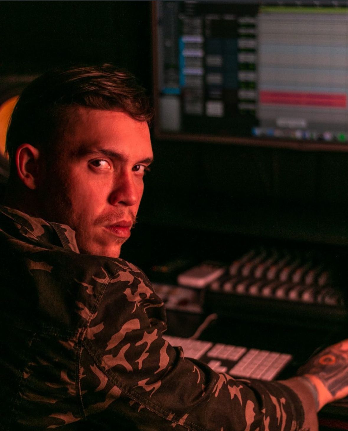 Produtor musical rap trabalhando em estúdio profissional com projeto aberto no computador