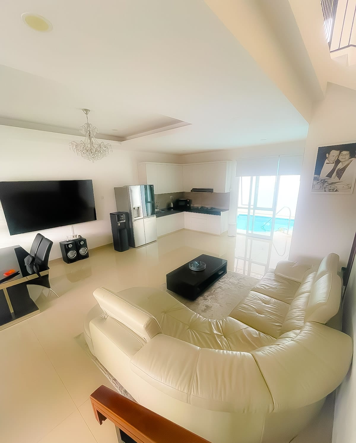 Modern living room at Villa Sattara Seminyak with leather sofa, 85-inch TV and open dining area