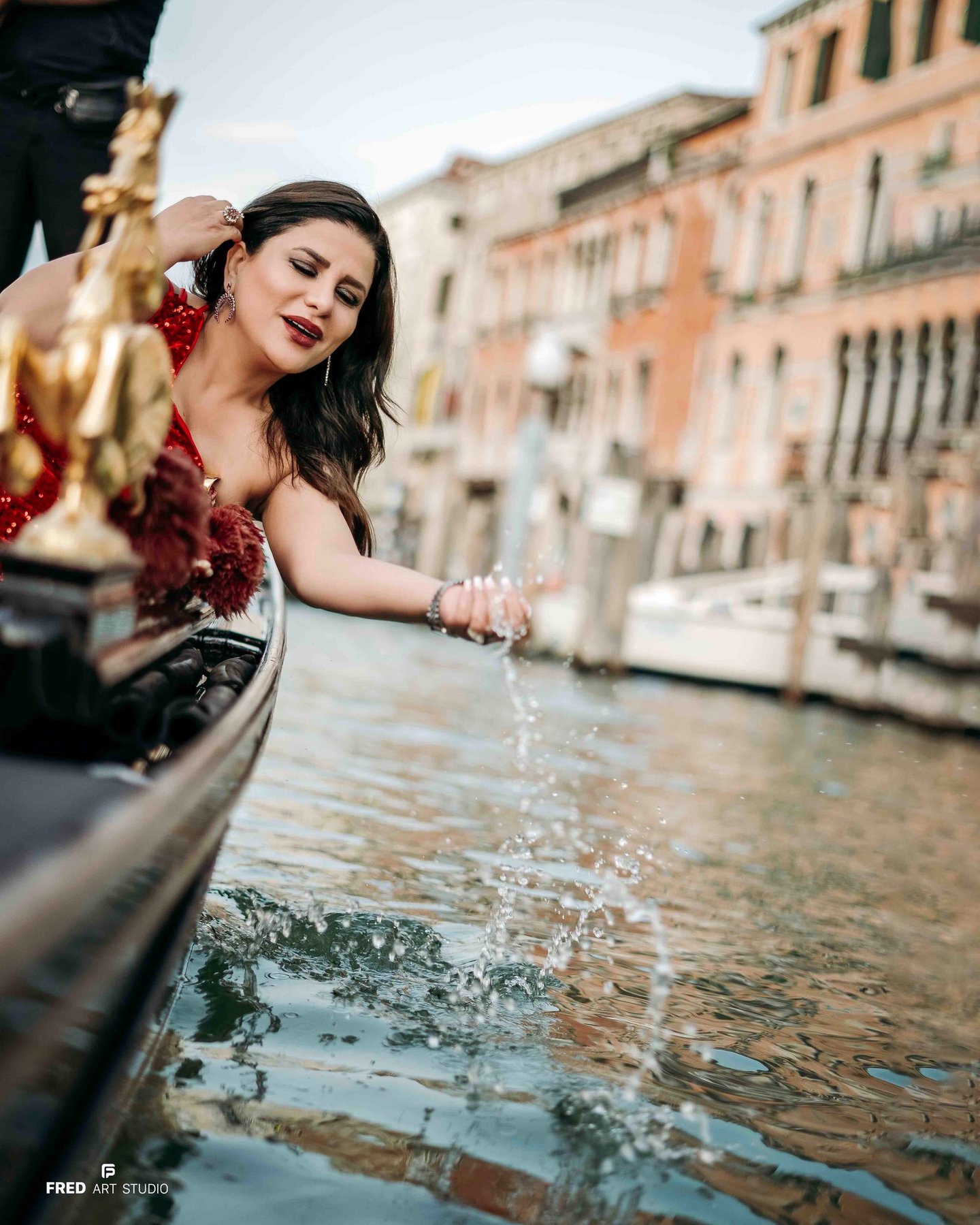 Woman in red dress on gondola in Venice