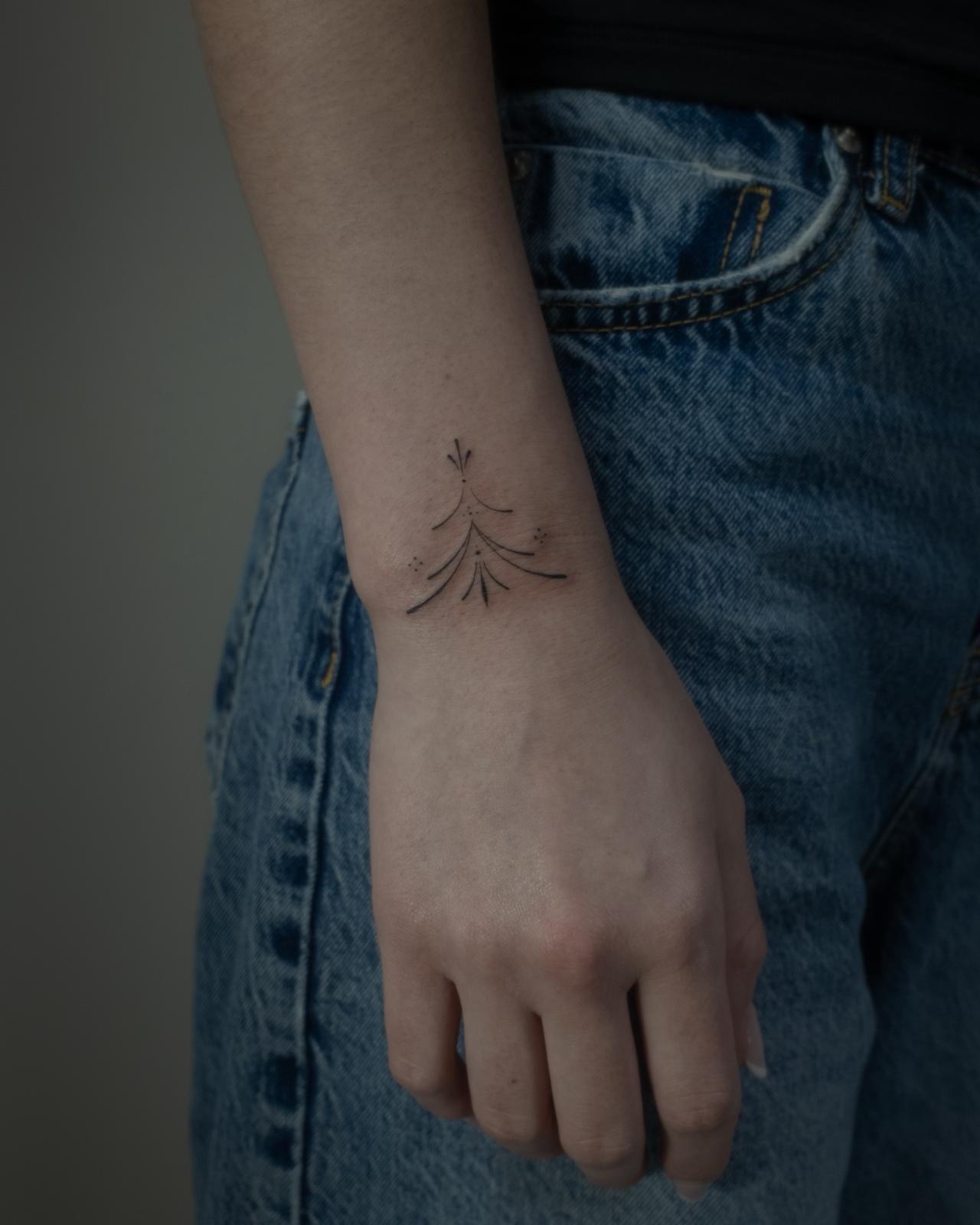 Tatuaje fineline en Madrid de composición abstracta con corazón y caligrafía gestual en línea contin