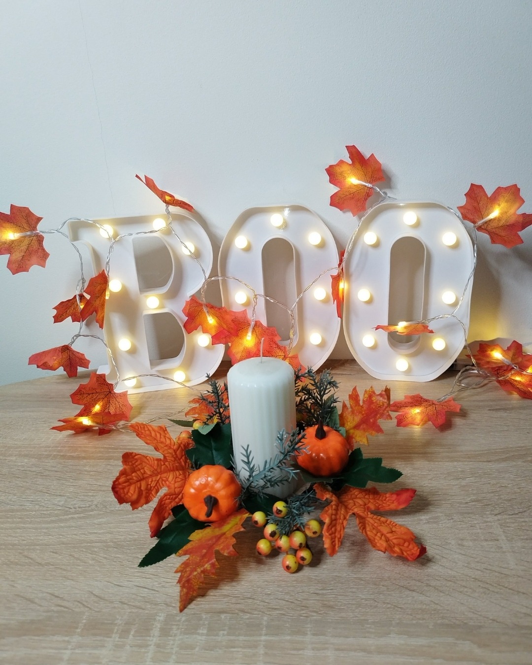Thanksgiving candle wreath with orange maple leaves, pumpkins, and berries