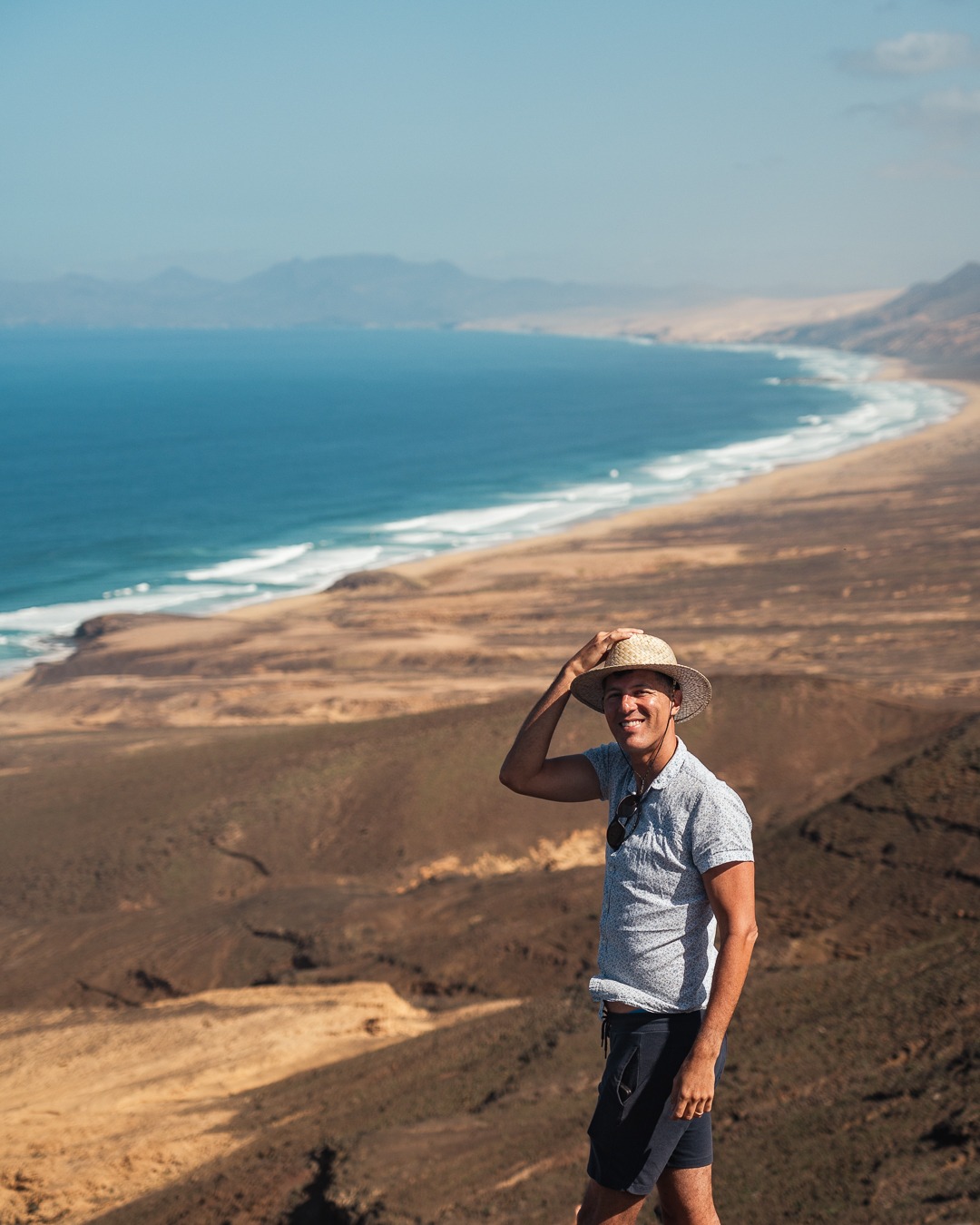 viajante apreciando paisagem costeira com falésias e oceano azul durante passeio ao ar livre