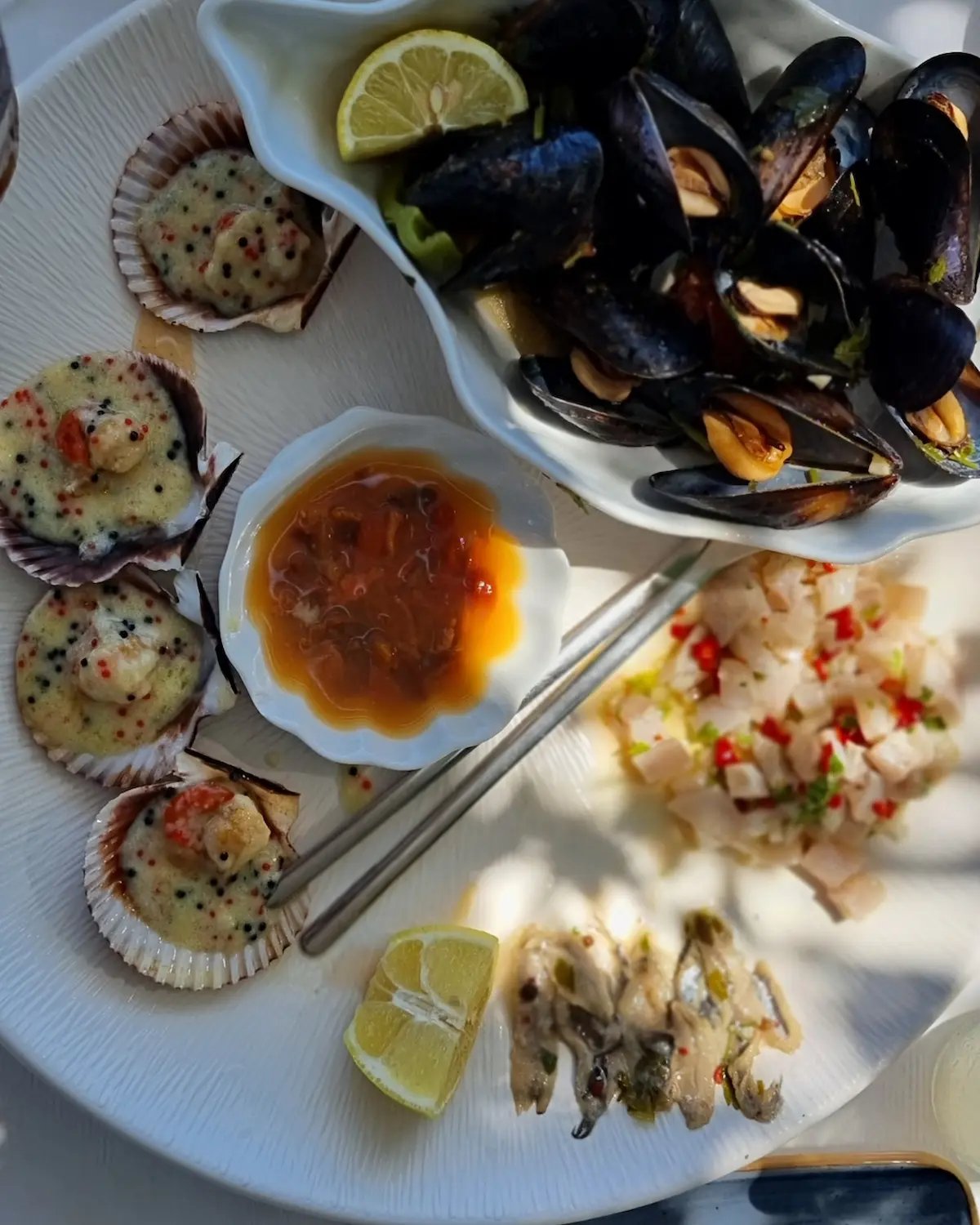 a plate of food with a bowl of food and a glass of wine