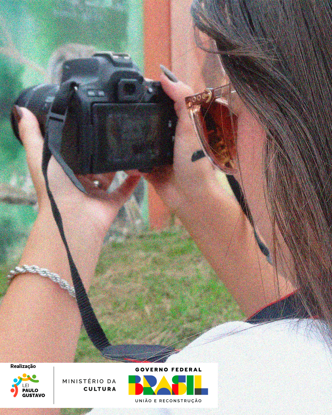 Uma mulher segurando uma câmera fotográfica