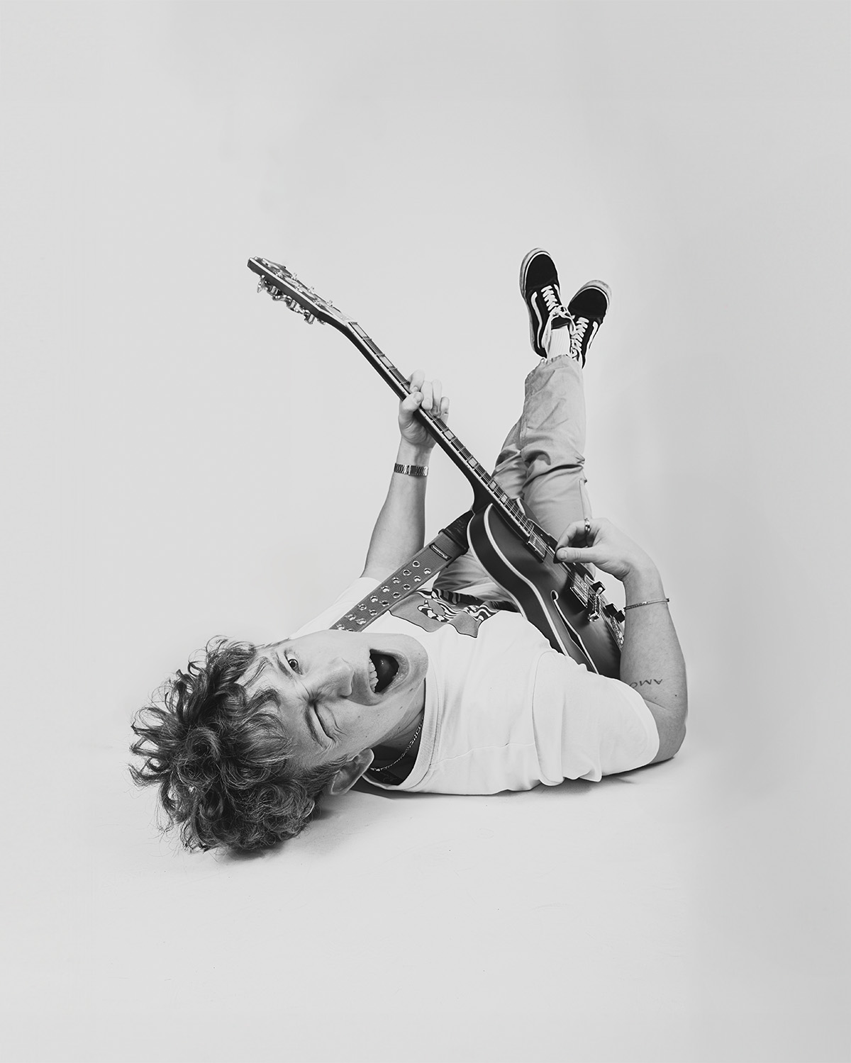 portrait of a man lying with a guitar and a guitar