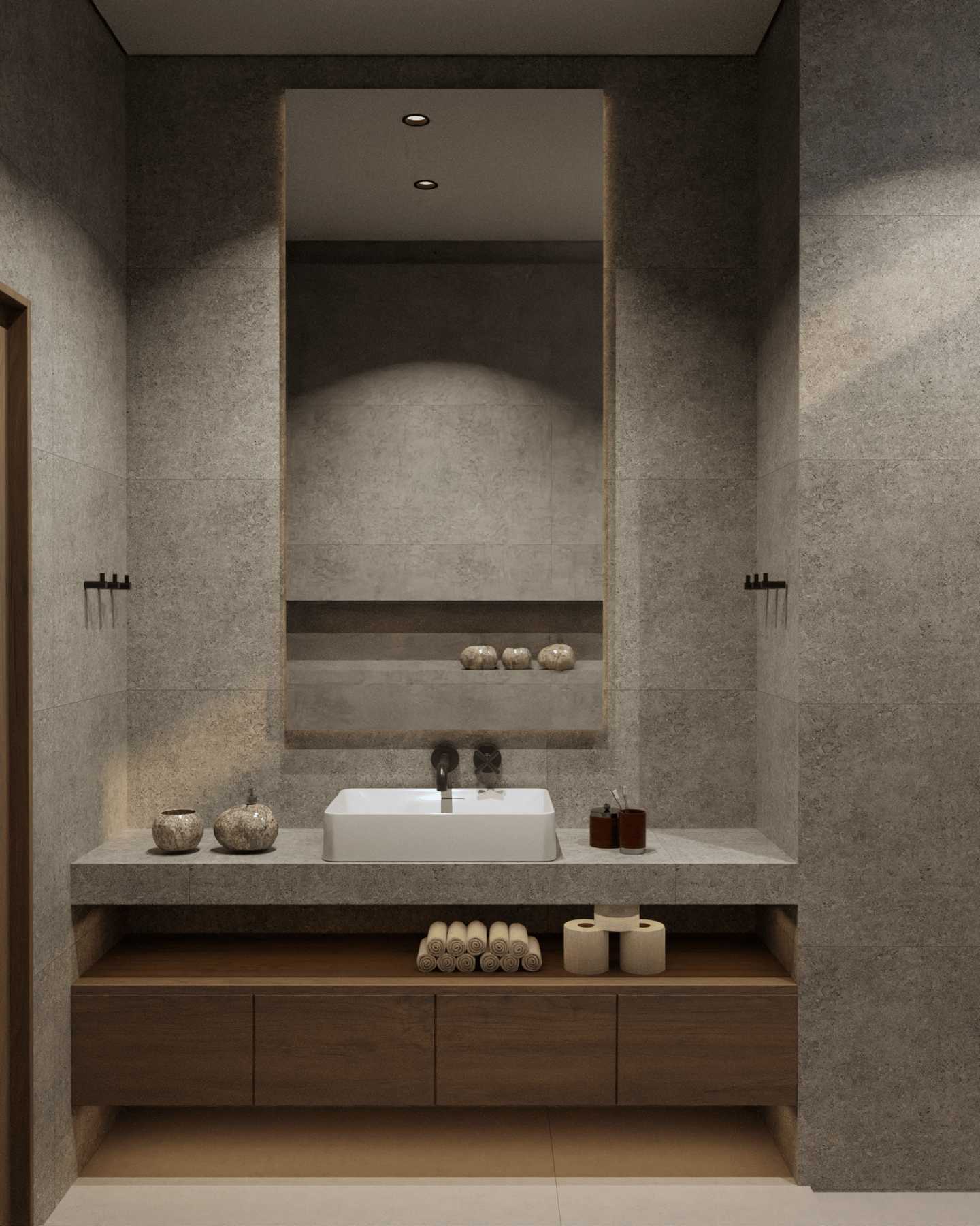 Modern bathroom featuring stone tiles and a large illuminated mirror.