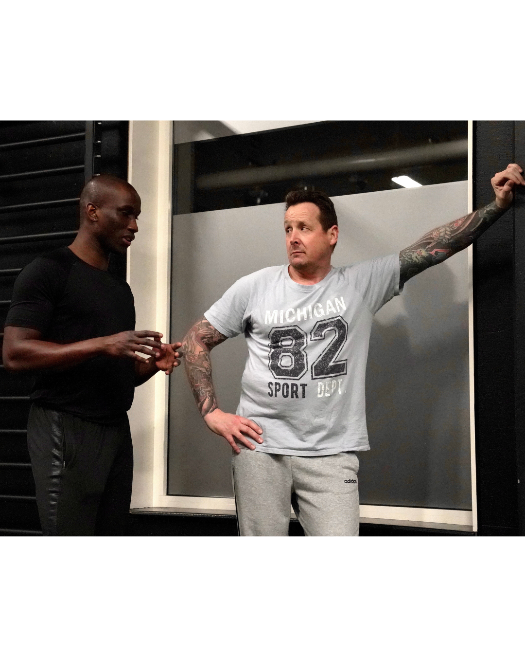 A personal fitness trainer talks to a client during a gym workout session.