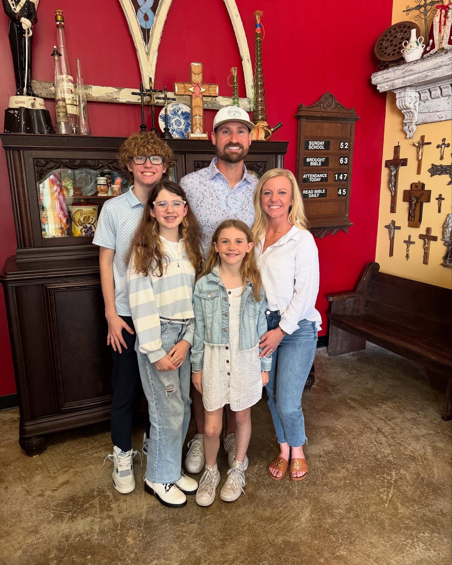 a photo of the family that owns race ready events standing in front of a bright red backdrop