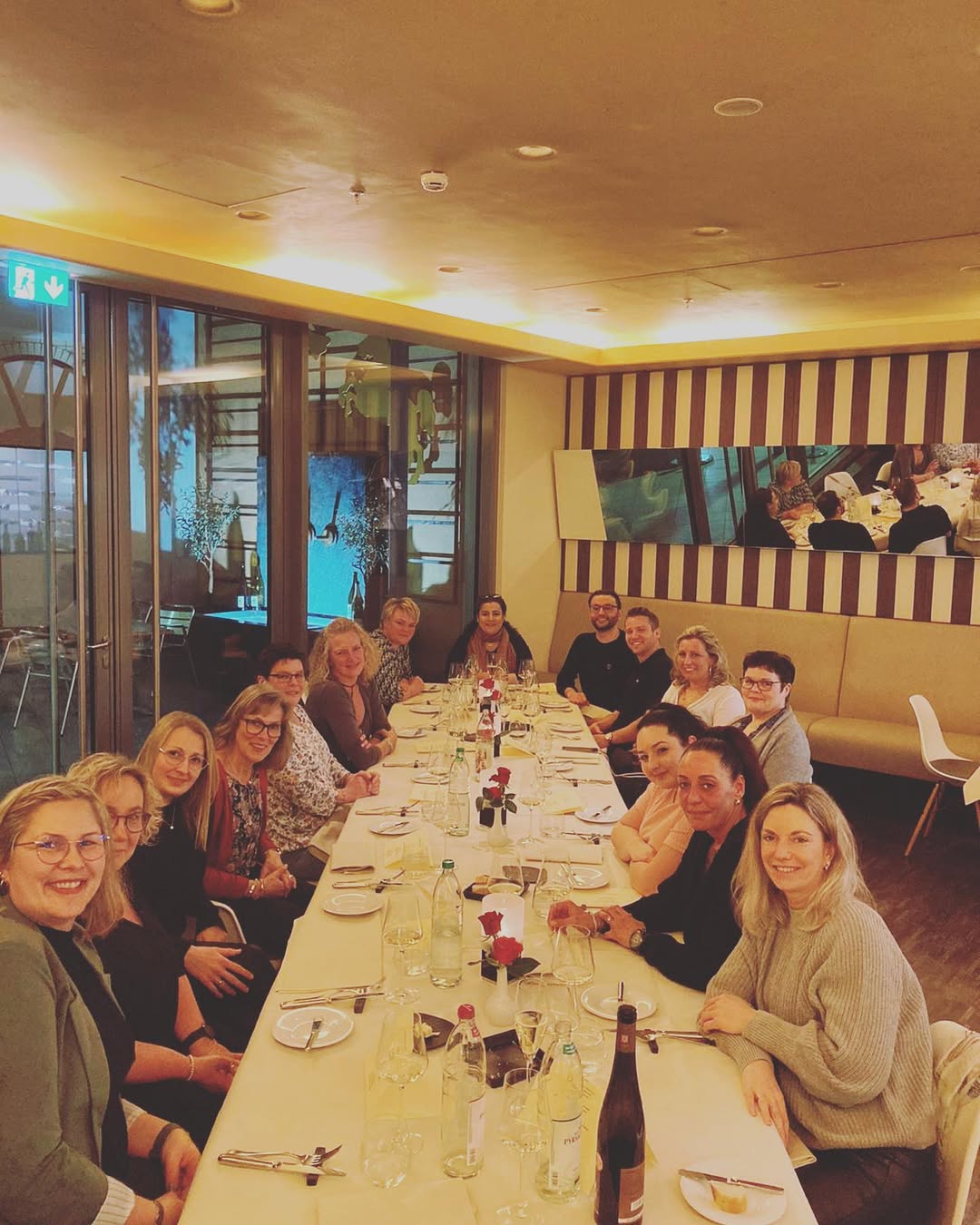 a group of people sitting at a long table
