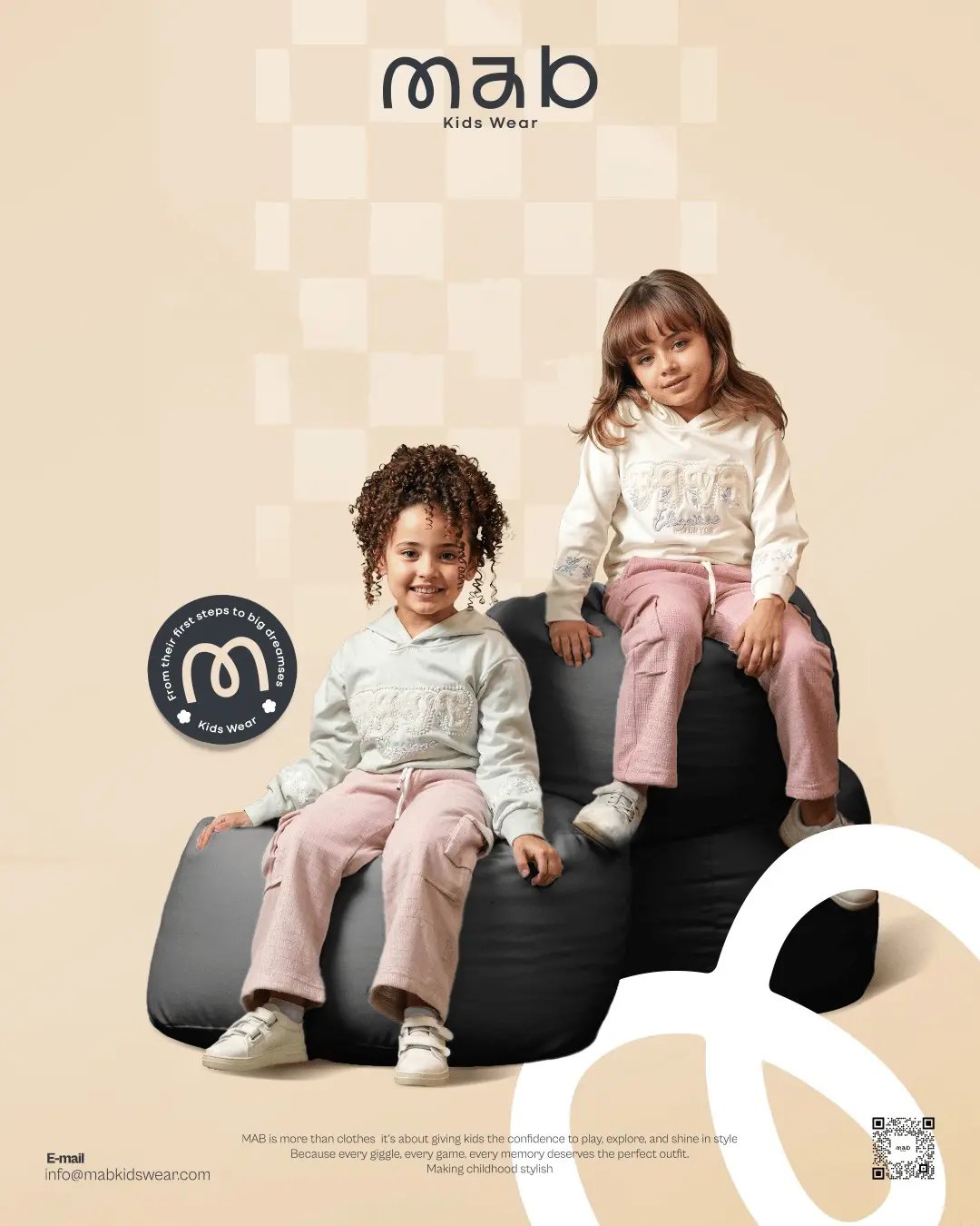 Two girls modeling Mab Kids Wear hoodies and pink jogger pants on black bean bags.