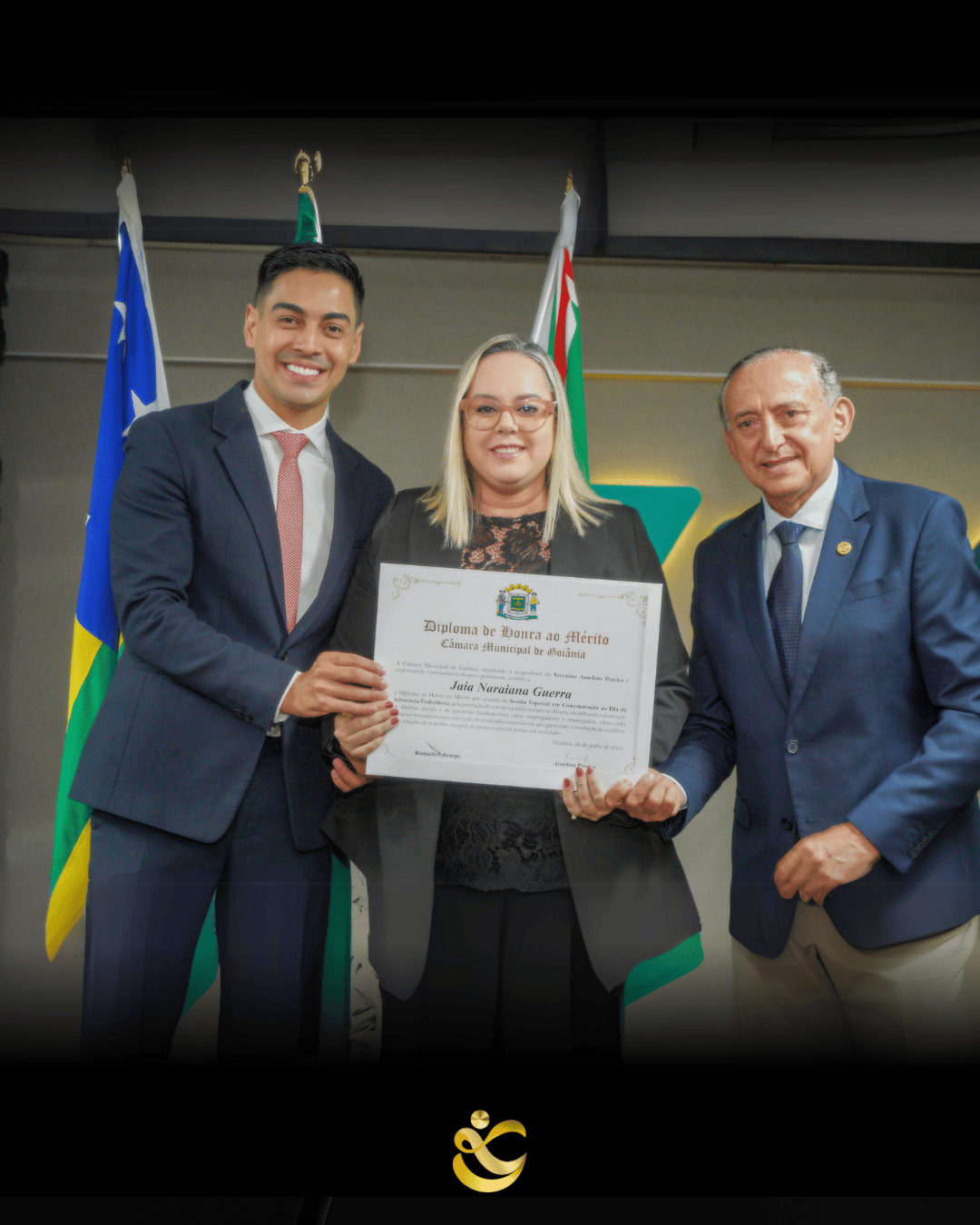 Dois homens e uma mulher ao meio recebendo um certificado