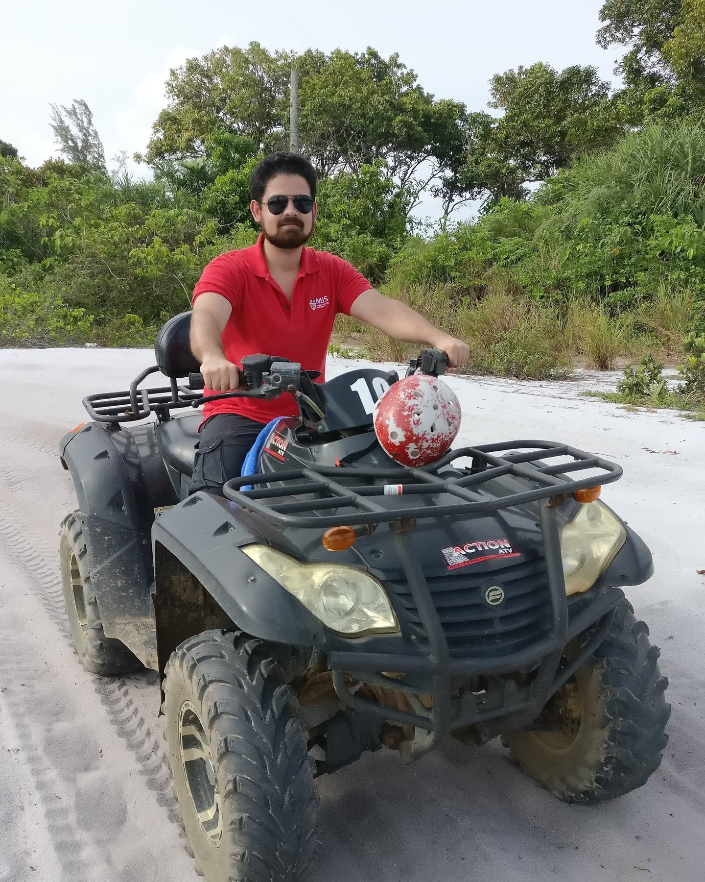 Bhargav sitting on an ATV at a beach in Indonesia