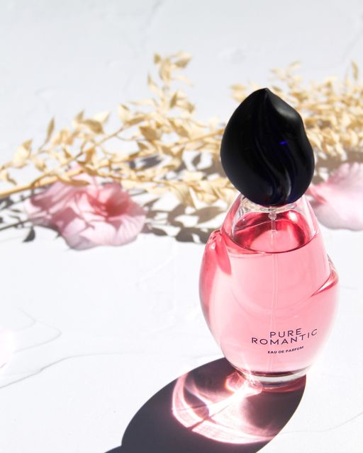 flacon parfum devant bouquet de fleurs