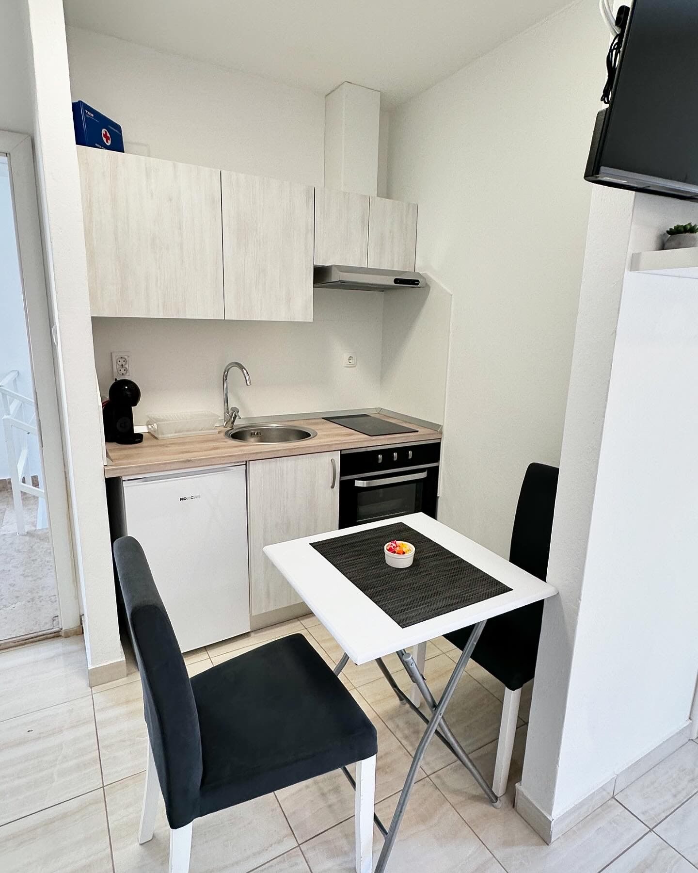 kitchen with coffe machine, fridge table and chairs